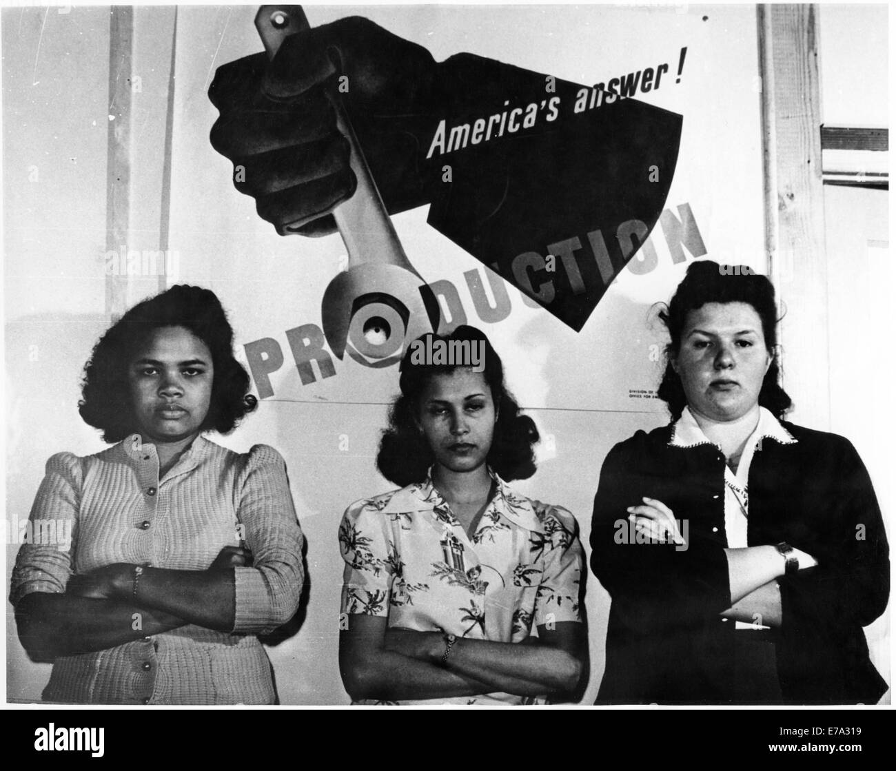 Drei weibliche Fabrikarbeiter stehen vor "Amerikas Antwort! Produktion "Plakat während des zweiten Weltkriegs, circa 1943 aus dem dokumentarischen Film,"Die neue Frau", Frauenfilm projizieren, 1974 Stockfoto