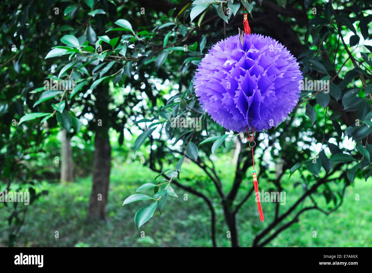 Origami Papier Blumen Kugel hängen am Baum im Kinderpark in China. Stockfoto