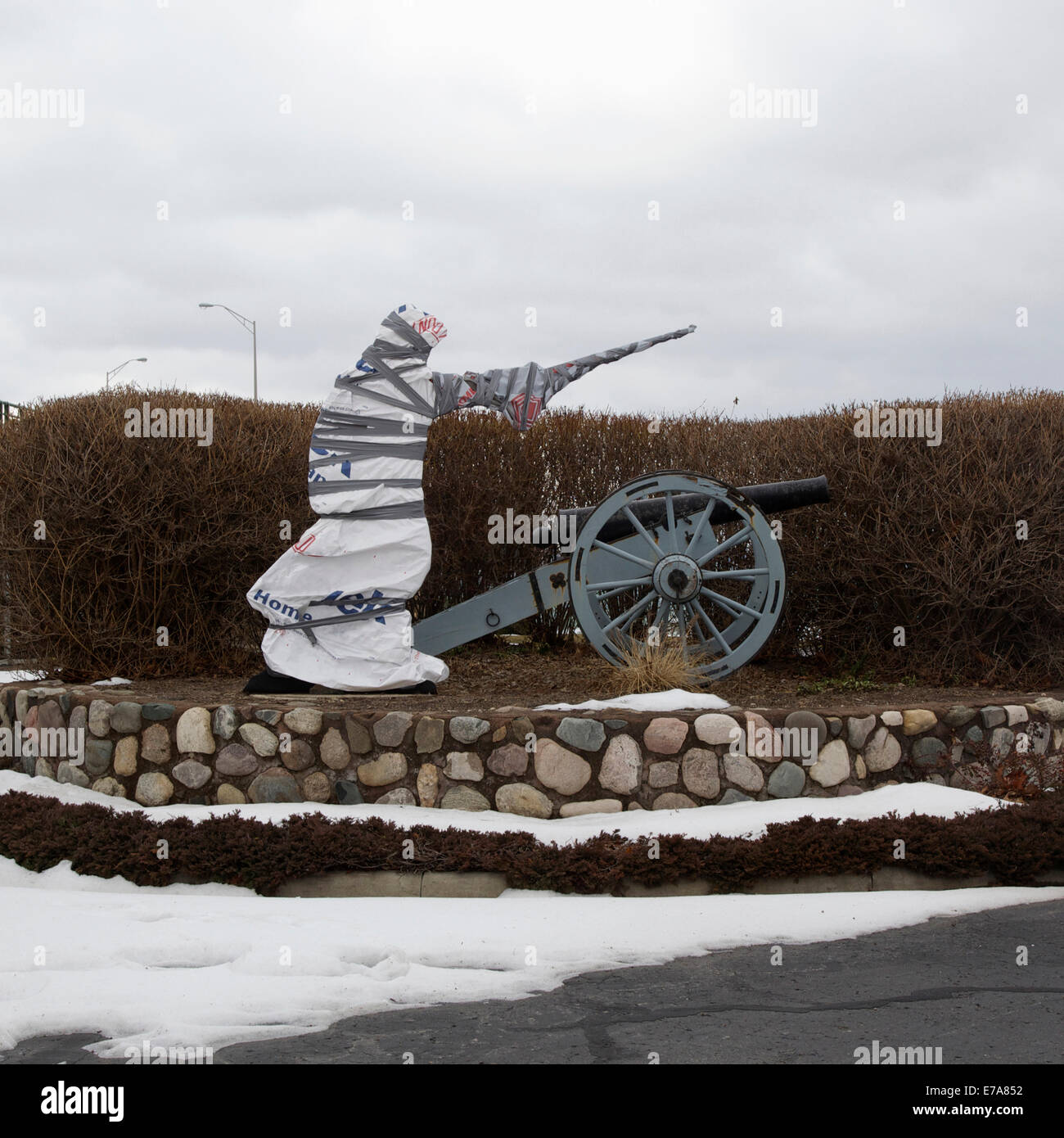 Eine überdachte Statue neben eine alte Kanone Stockfoto