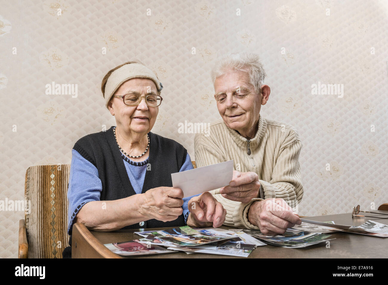 Senior paar geht durch die Bilder zu Hause Stockfoto