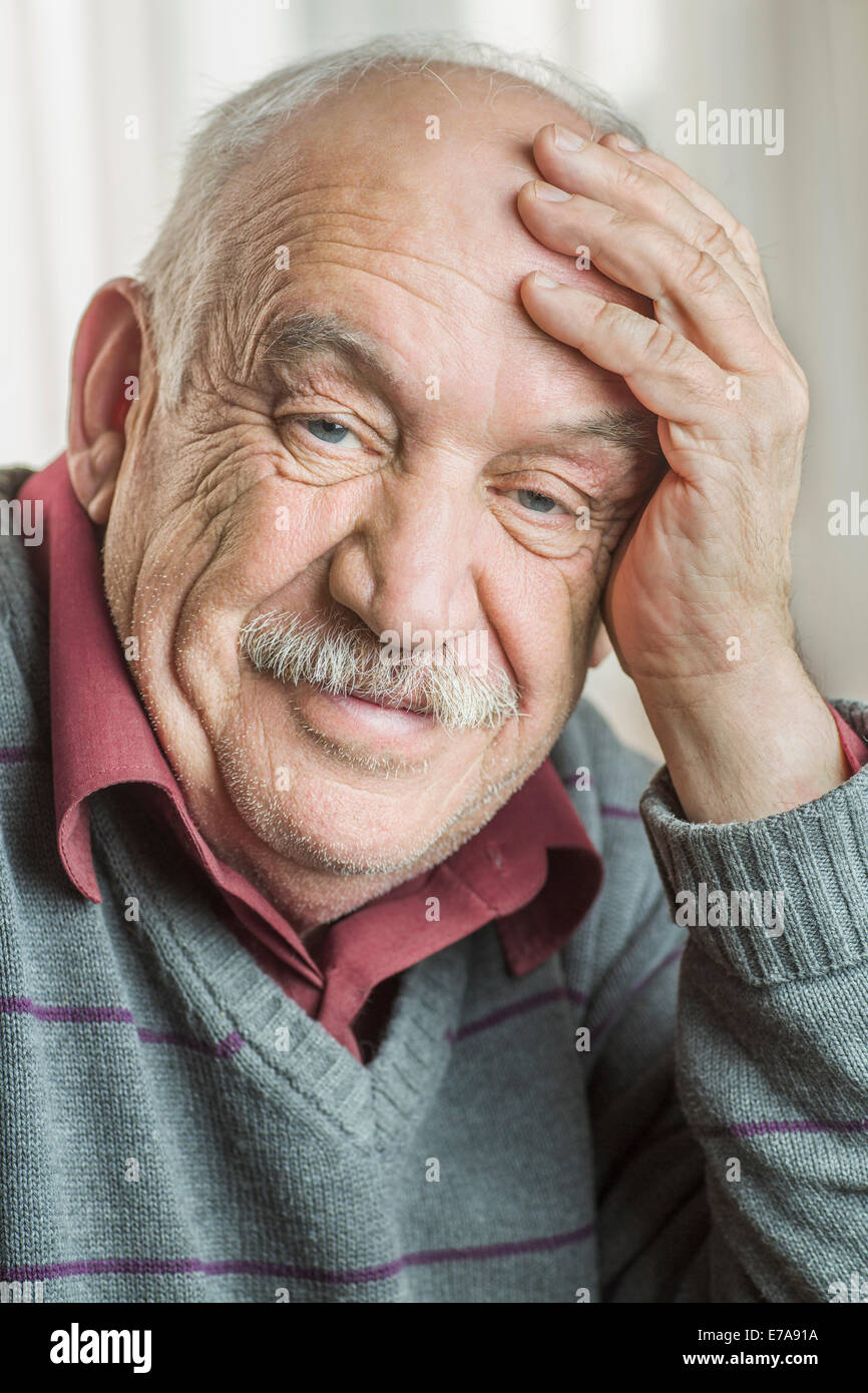 Porträt von besorgt senior Mann mit Kopf in der Hand zu Hause Stockfoto