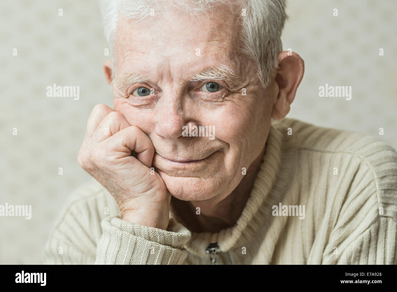 Close-up Portrait des Lächelns senior Mann mit Hand am Kinn Stockfoto