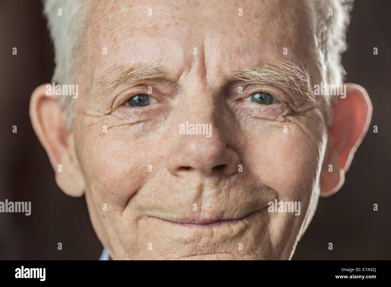 Close-up Portrait des Lächelns senior woman über farbigen Hintergrund Stockfoto