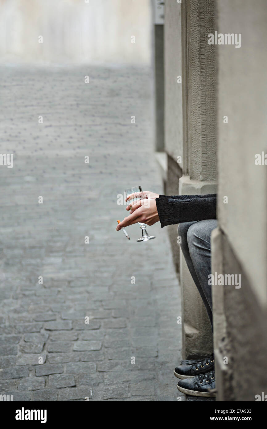 Bild Frau mit Zigarette und Weinglas vom Bürgersteig beschnitten Stockfoto