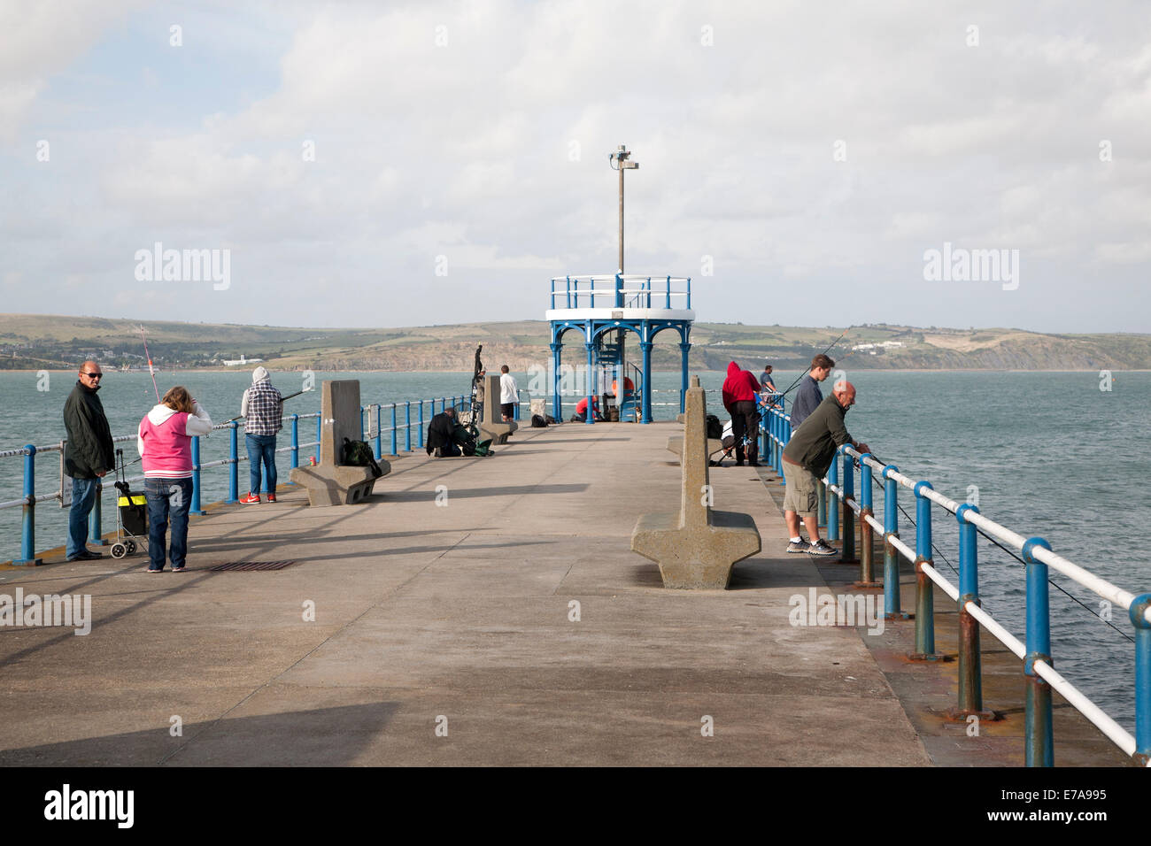 Menschen, die Angeln vom Wellenbrecher Hafenpier bei Weymouth, Dorset, England Stockfoto