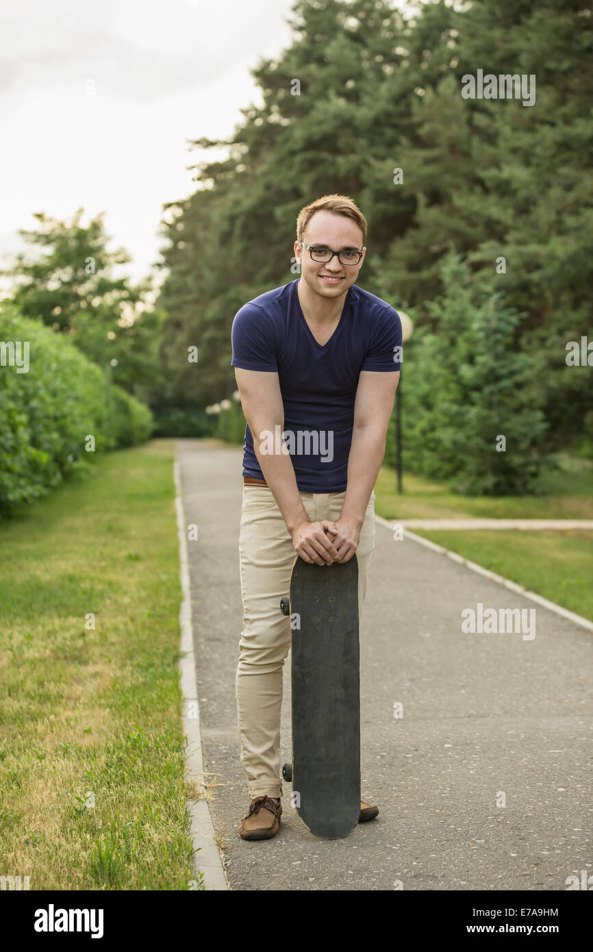 In voller Länge Portrait von junger Mann hält Skateboard im park Stockfoto