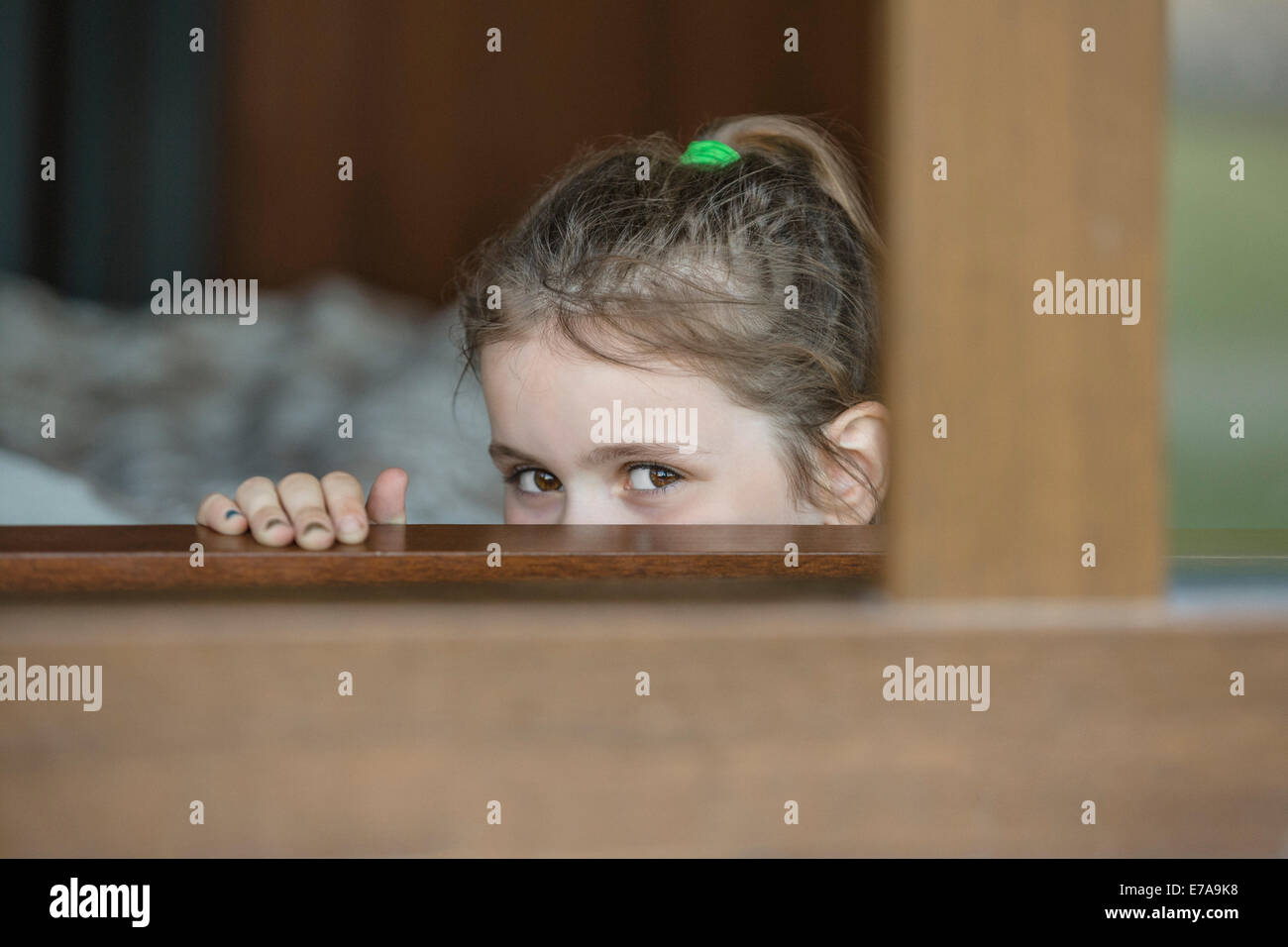 Porträt eines Mädchens durch Fenster spähen Stockfoto