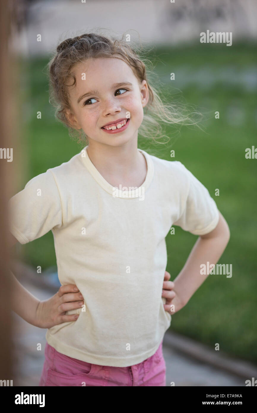 Fröhliches Mädchen mit die Hände auf die Hüfte wegschauen im park Stockfoto