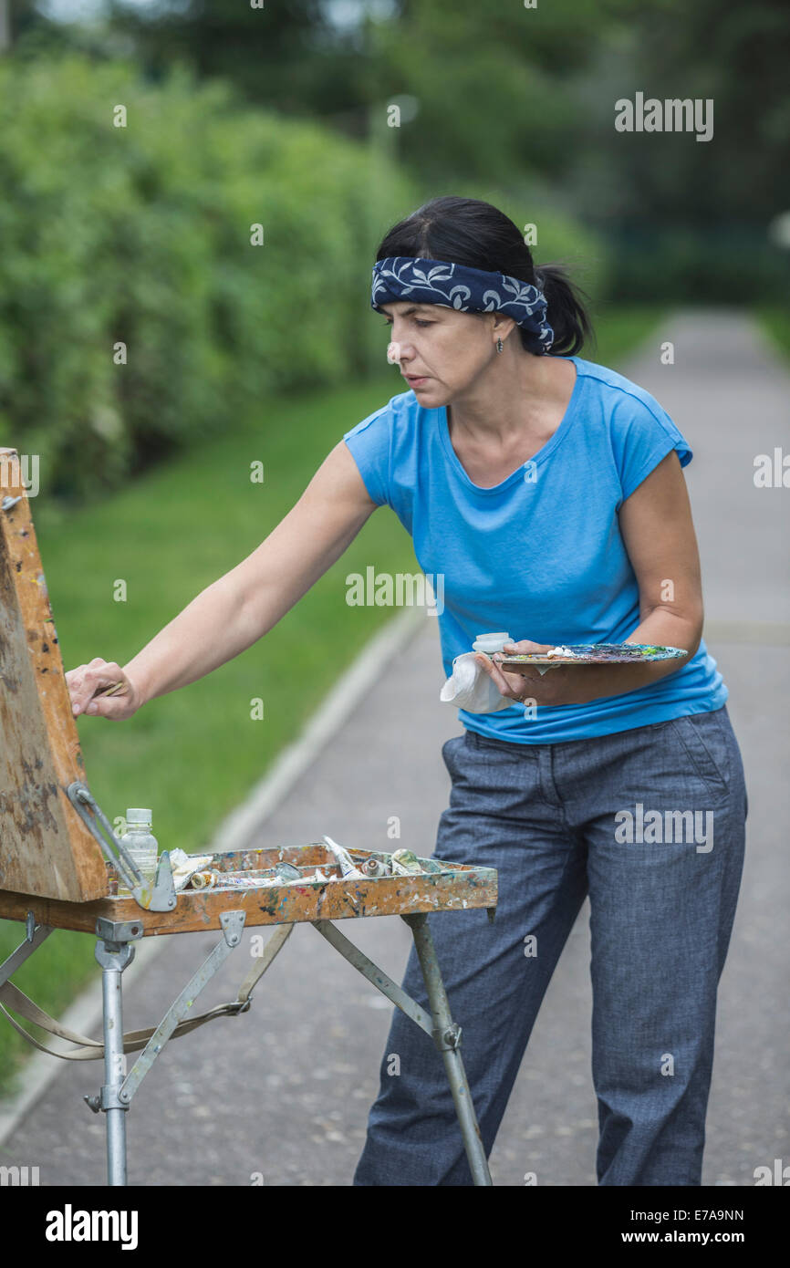 Reife Frau malen im park Stockfoto