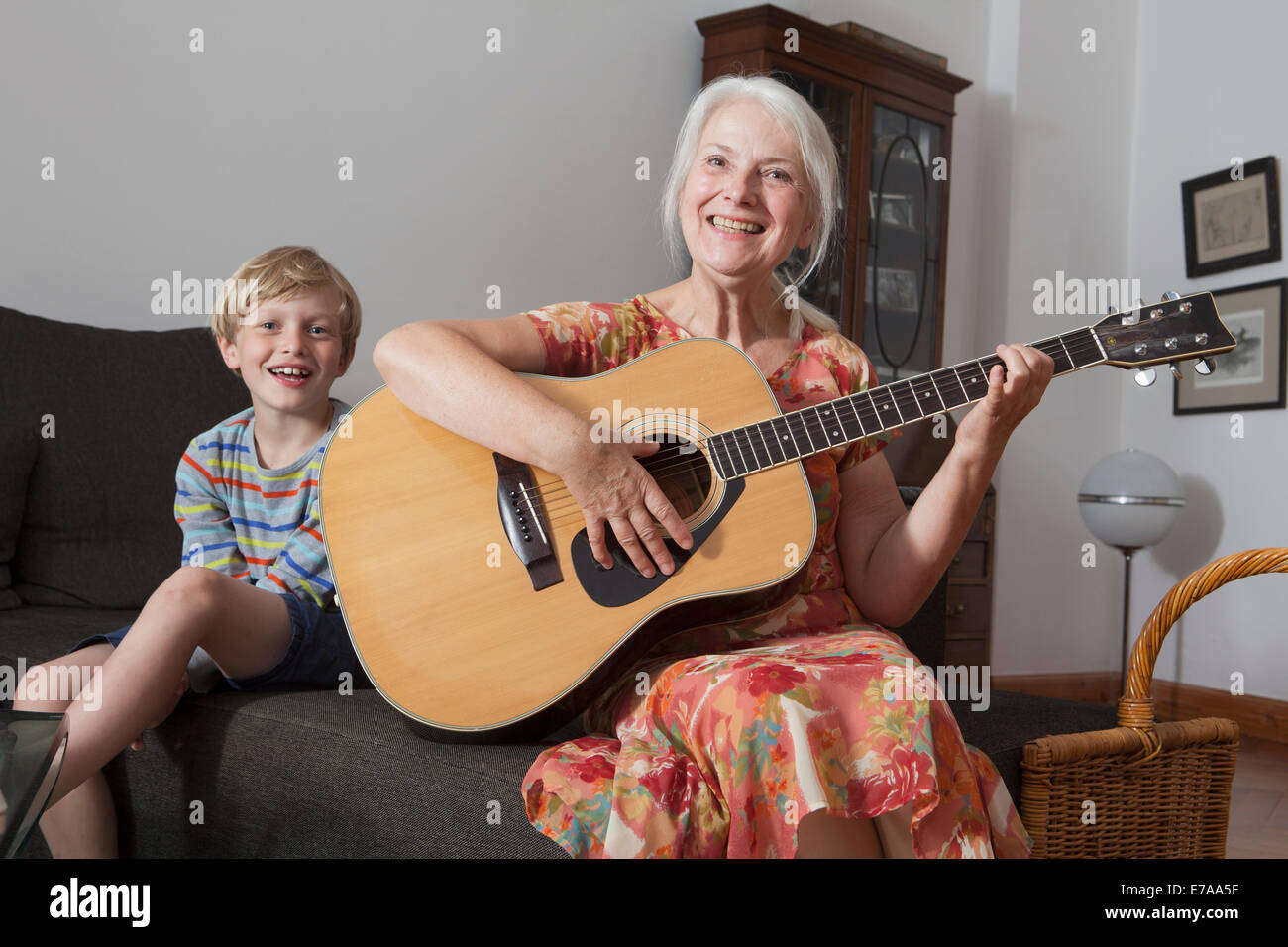 Porträt eines jungen mit Großmutter, die Gitarre zu Hause auf Sofa sitzen Stockfoto