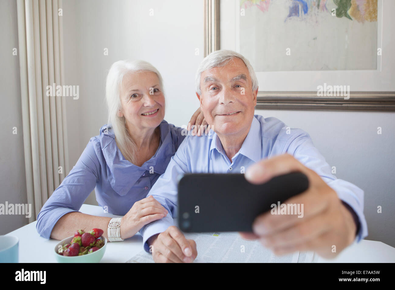 Gerne älteres paar Einnahme Selbstportrait durch Smartphone am Tisch im Haus Stockfoto