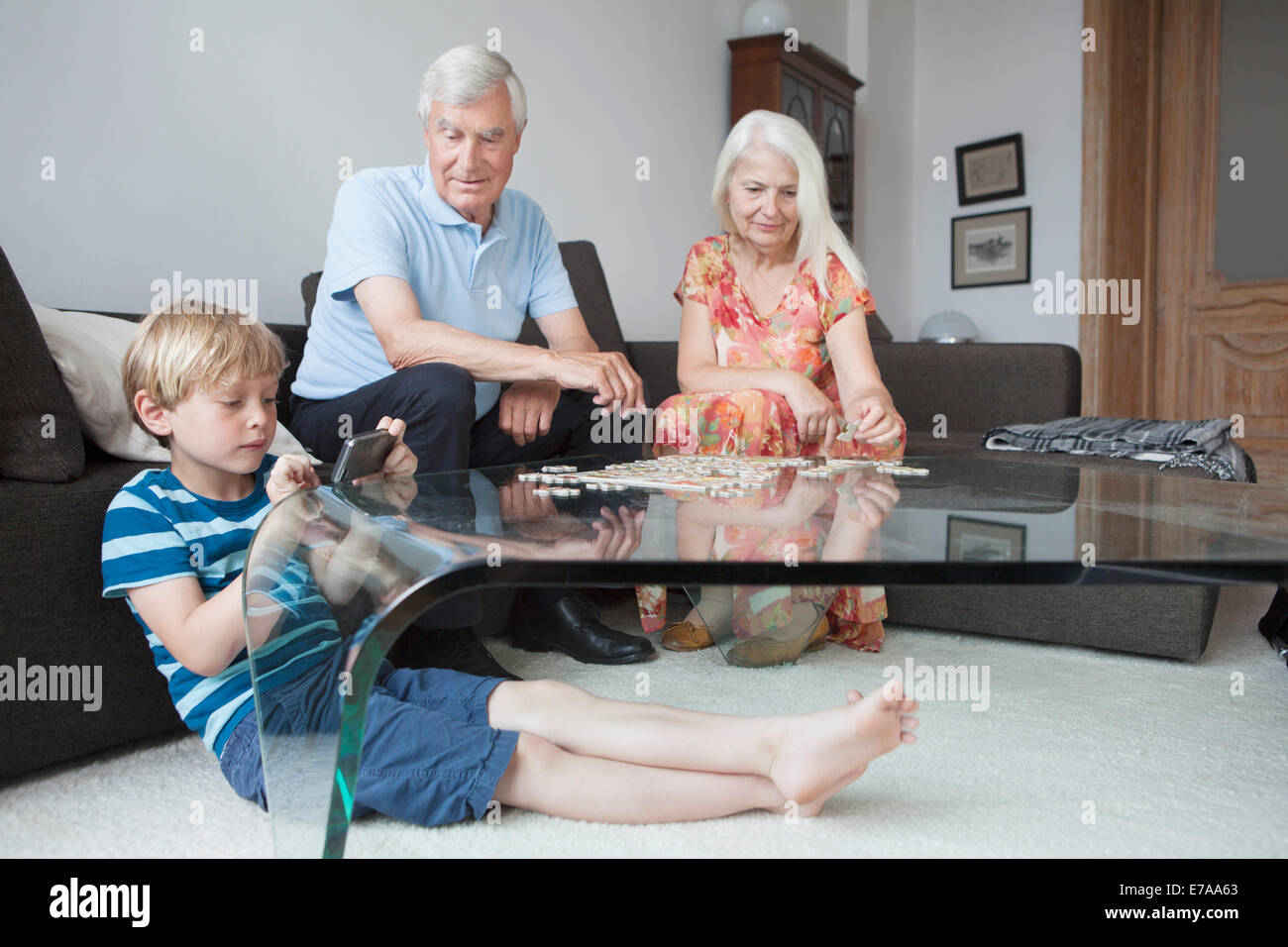 Großeltern und Enkel, die Freizeitgestaltung im Wohnzimmer Stockfoto