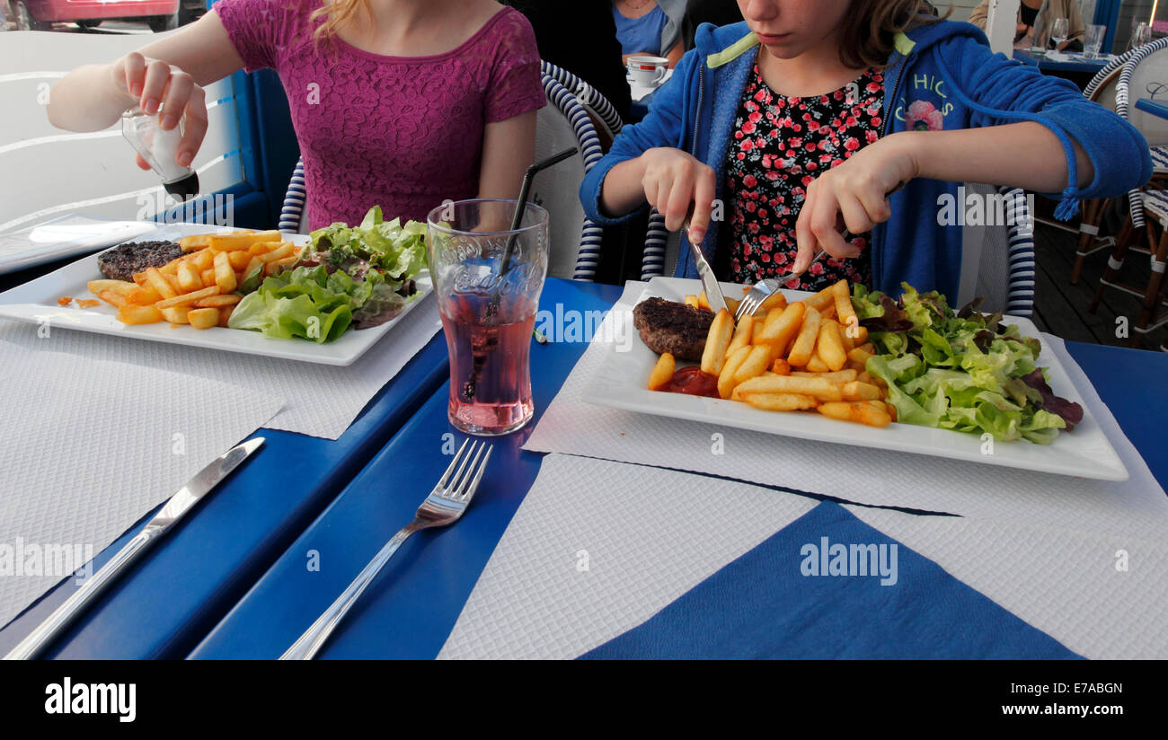 Zwei Kinder essen Hache Steak mit Pommes frites Stockfoto