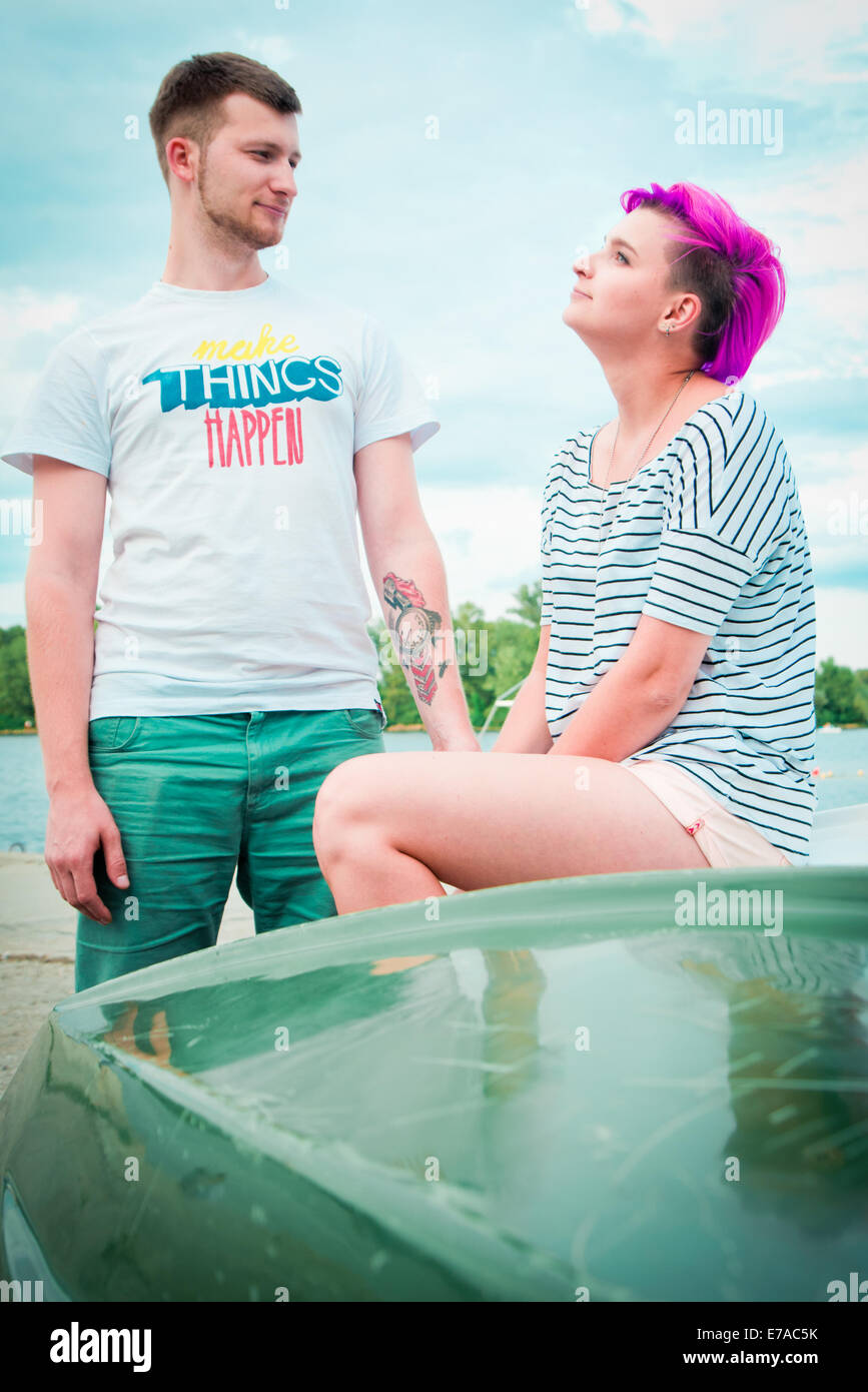 Mann und Frau sitzen auf einem umgedrehten Boot am Fluss Stockfoto