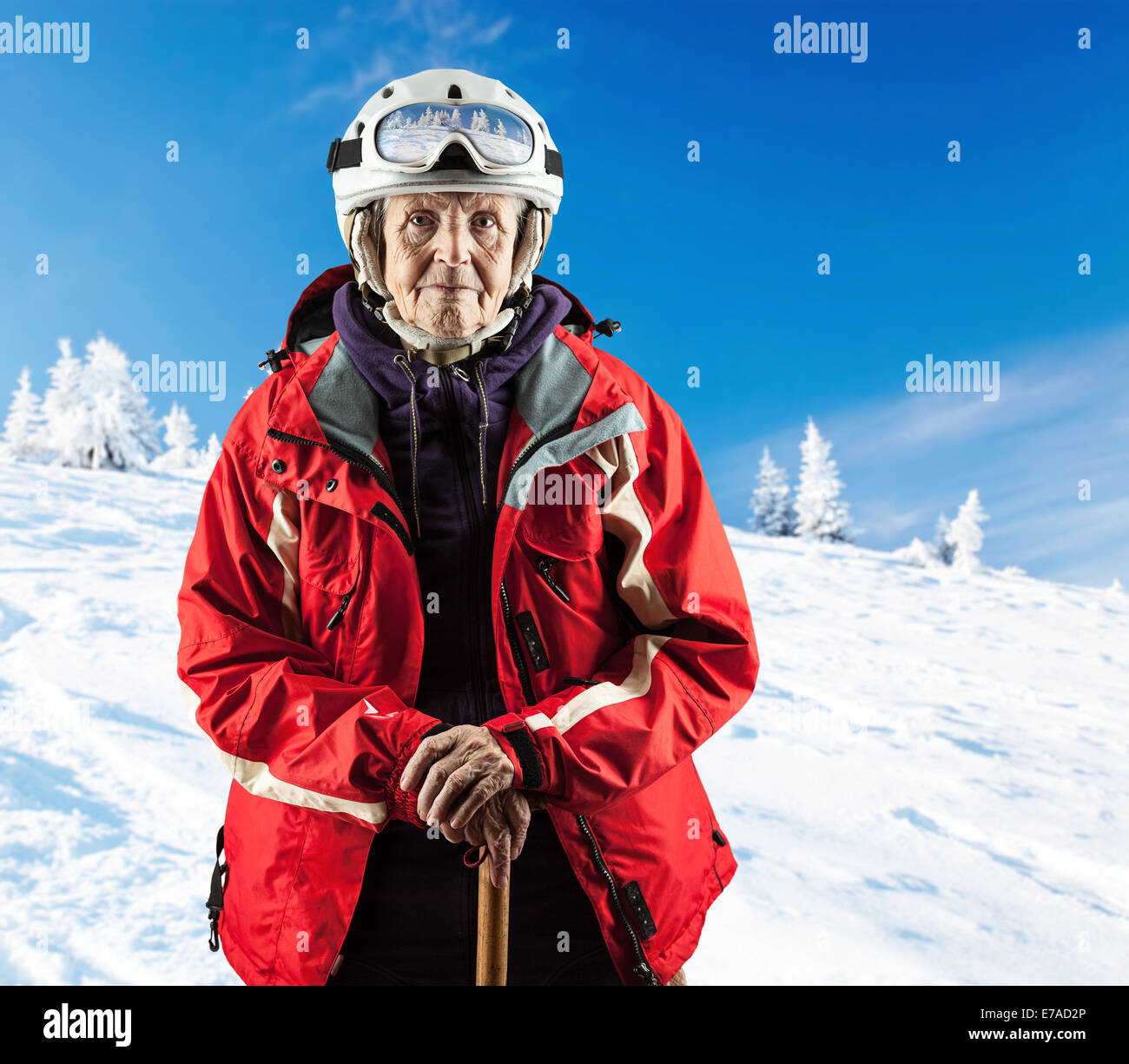 Senior Trägerin Skijacke und Schutzbrillen auf verschneiten Hang in Bergen. Mit Beschneidungspfad. Stockfoto