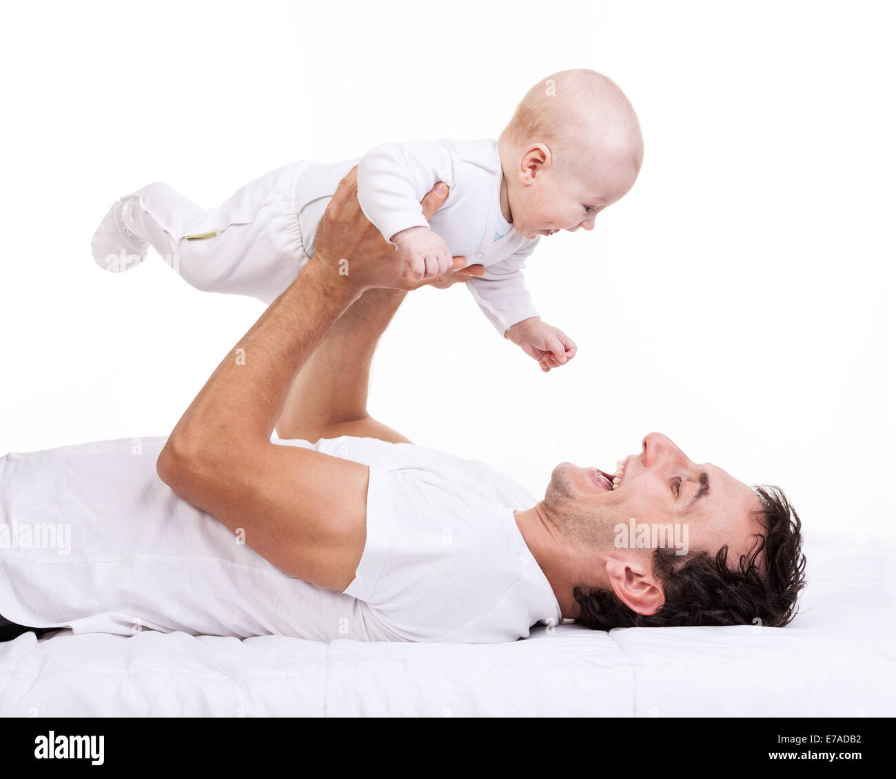 Glücklich Jüngling mit Baby Sohn während auf Rücken liegend Stockfoto