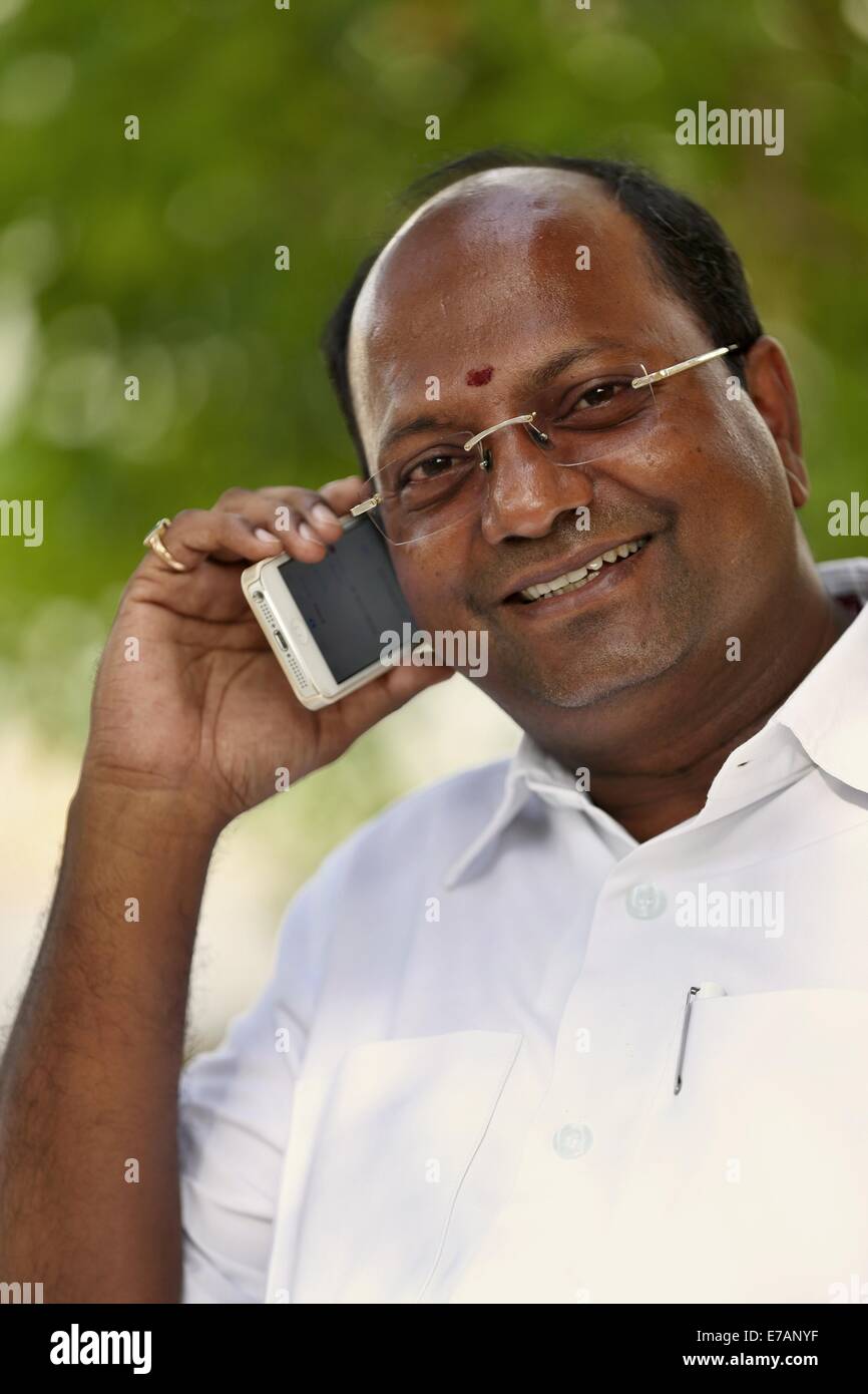 Sai Krishna aus der SREE PARTHISAI Vertrauen Puttaparthy sprechen auf seinem Handy - Indien Stockfoto