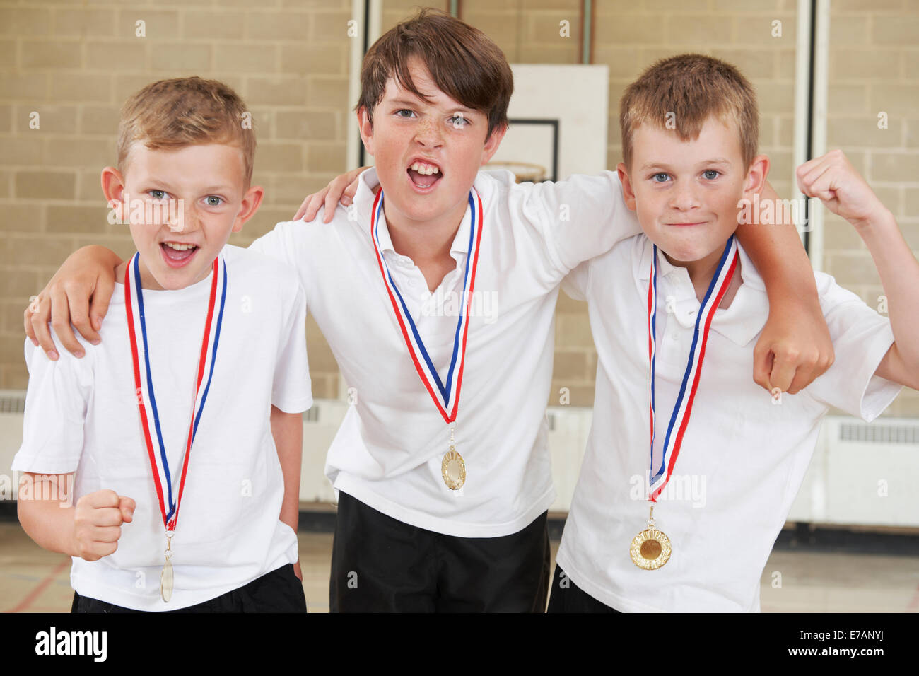 Männlich-Schule Sportmannschaft In Turnhalle mit Medaillen Stockfoto