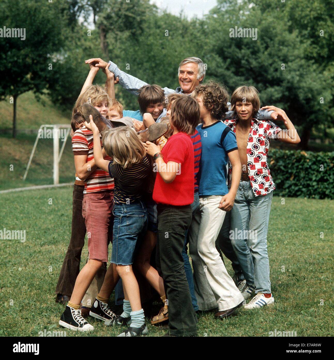 FILEPIX: Eine Datei vom 17. Juli 1973 Bild deutschen Schauspieler Joachim Fuchsberger in seiner Rolle als Lehrer Dr. Johannes Boekh, Spitzname "Justus", mit jungen Schauspielern, die Studenten zu spielen, während der Dreharbeiten das Kinderbuch Klassiker "Des fliegende Klassenzimmers" in Bamberg, Deutschland. Fuchsberger starb am 11. September 2014 im Alter von 87 in seinem Haus in Grünwald bei München. Foto: Horst Ossinger, Dpa/Alamy Live-Nachrichten Stockfoto