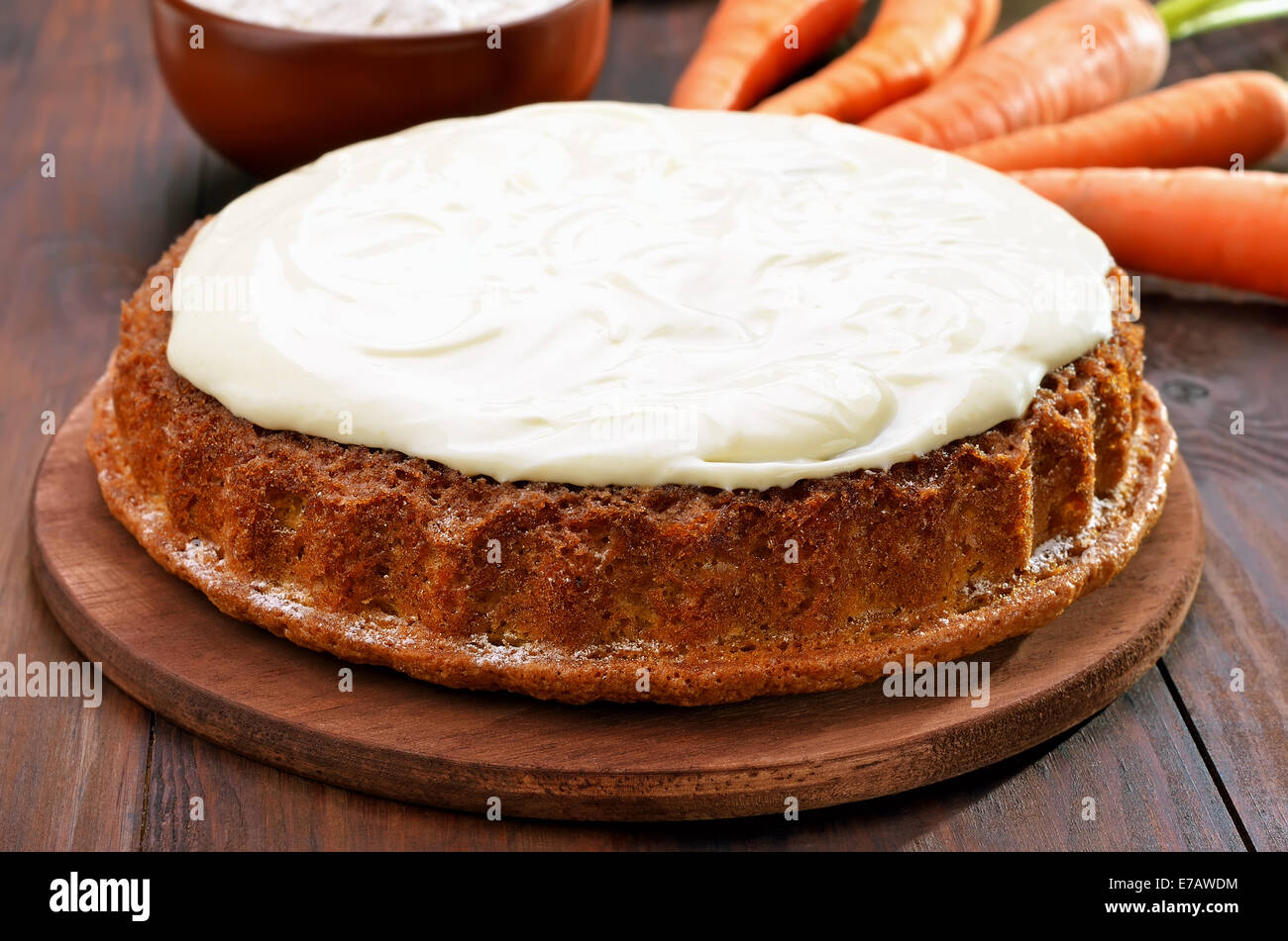 Karotte-Kuchen mit Zuckerguss auf Holztisch Stockfoto