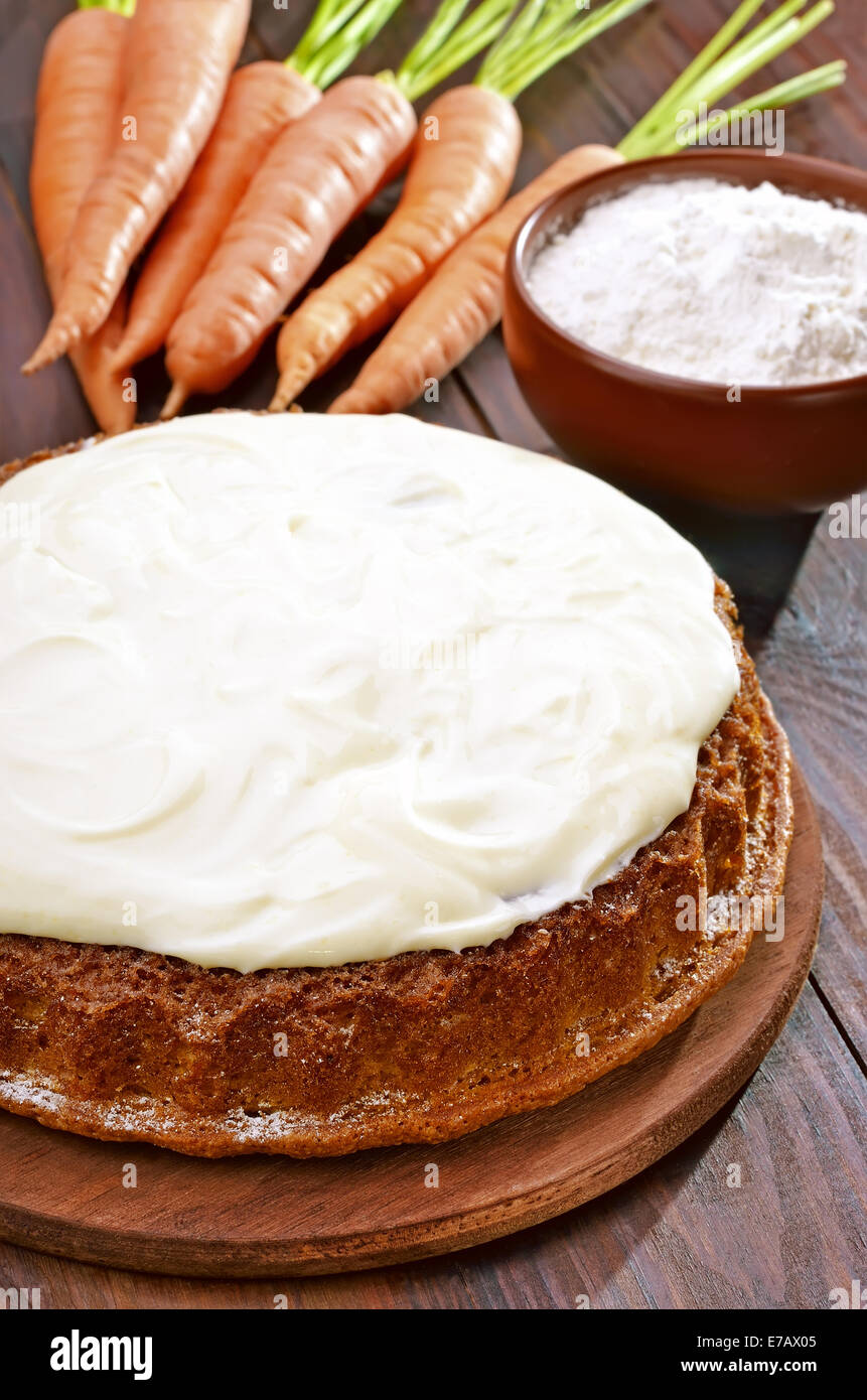 Karotte-Kuchen mit Zuckerguss auf Holztisch Stockfoto