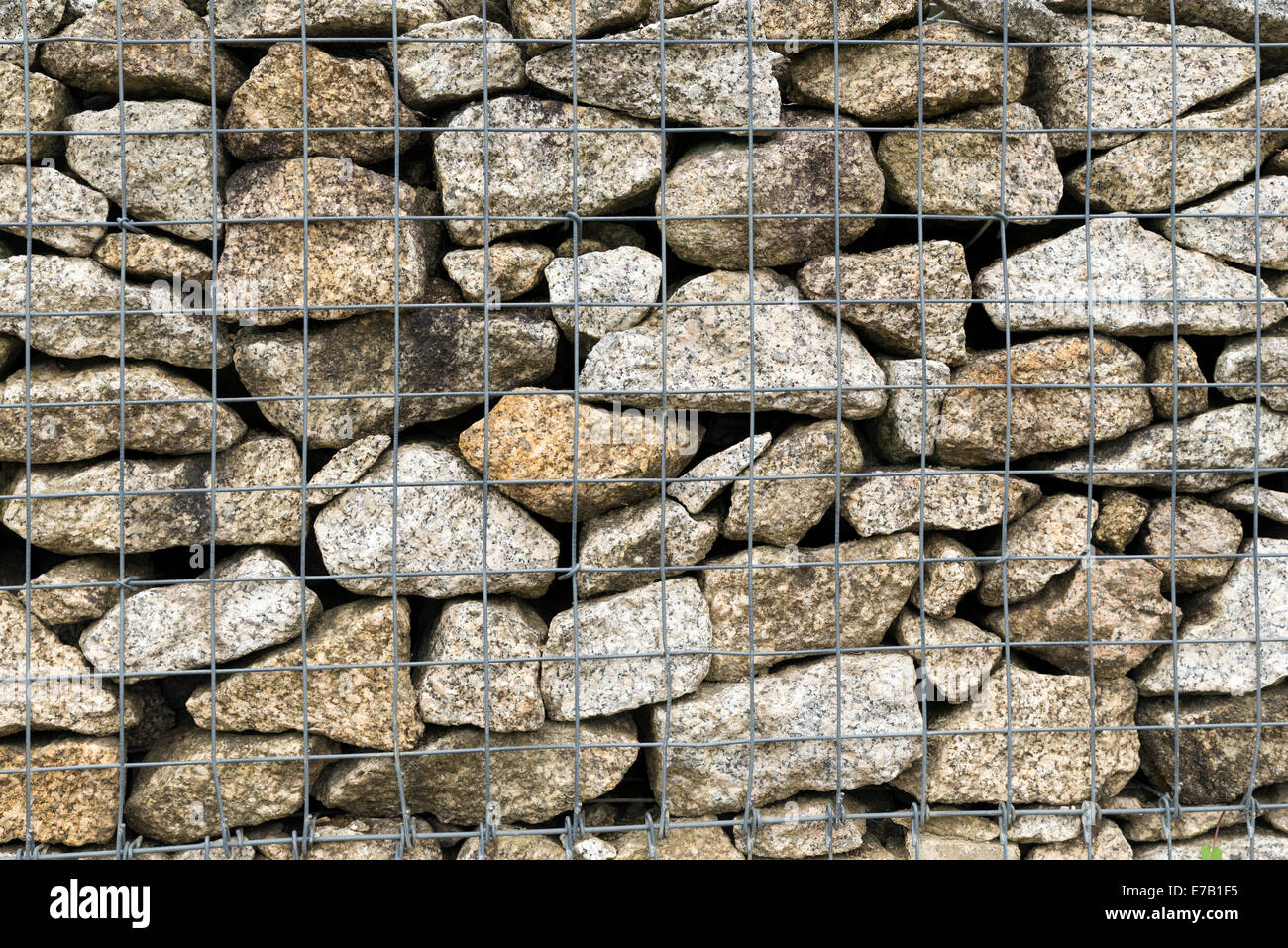 Eine riesige Gabione Wand als ein Zaun an einem Hang. Bunten Steinen ideal für verschiedene Arten von Hintergründen. Stockfoto