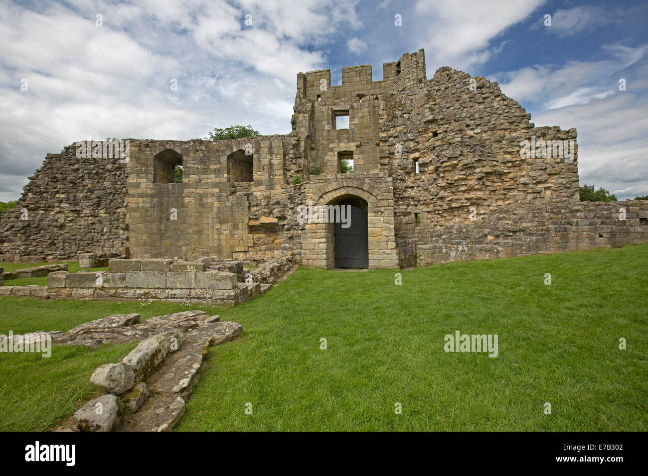 Ruinen des historischen Schlosses mit grünen Wiesen und blauem Himmel in Warkworth Northumberland, England Stockfoto