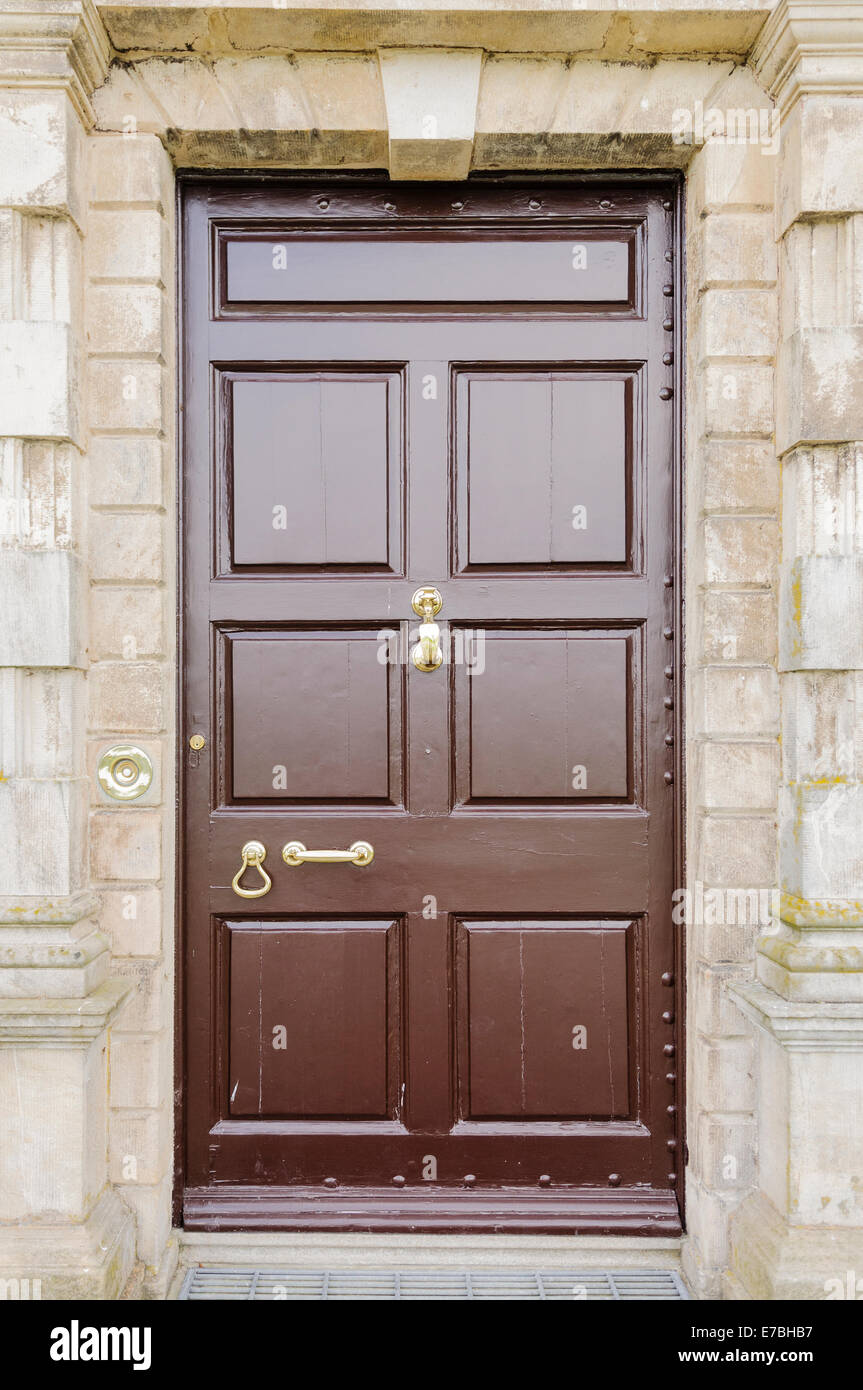 Große hölzerne Eingangstür zu einem Haus mit Messing Tür Möbel Stockfoto