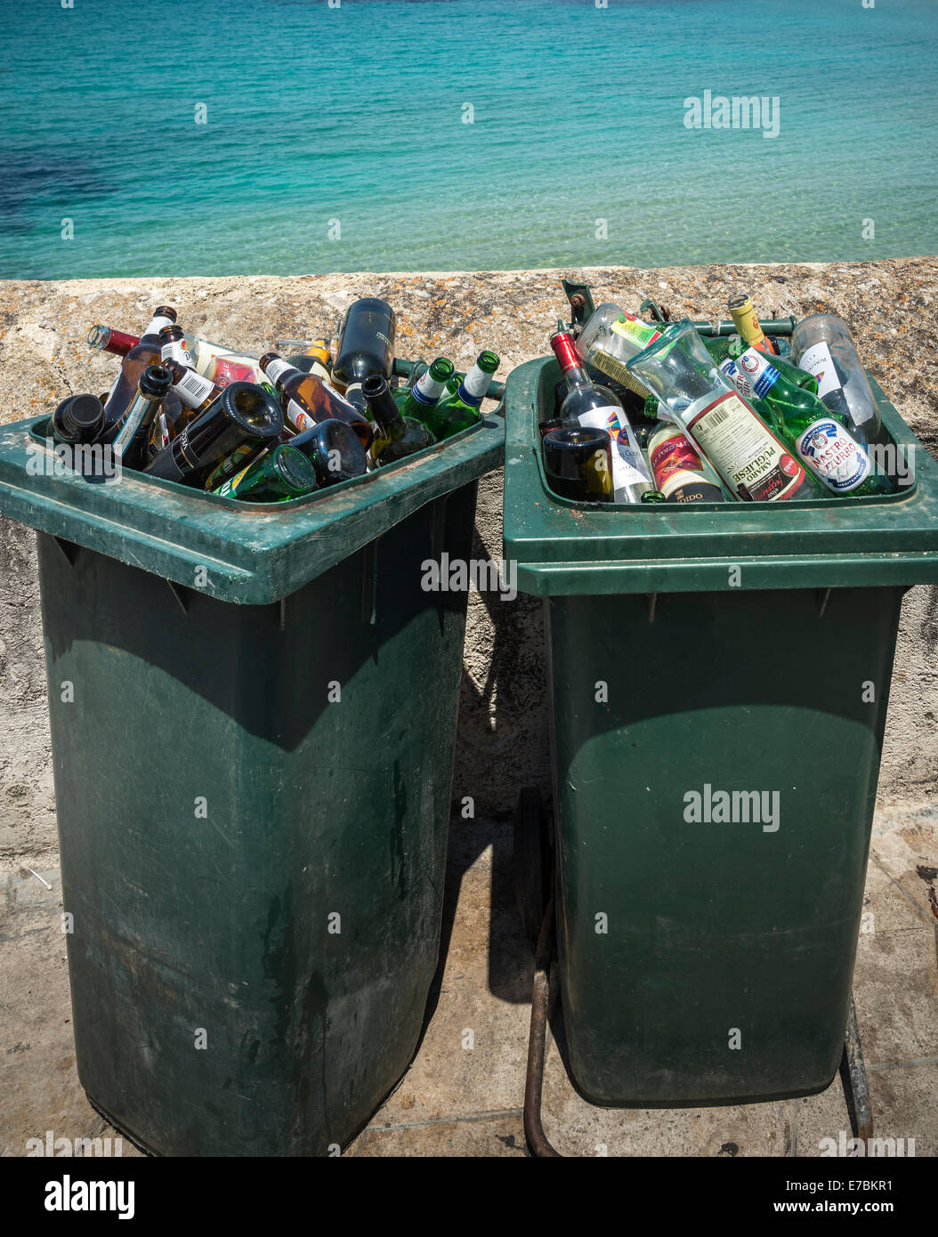 Weggeworfene Flaschen Alkohol in Mülltonnen am Meer. Stockfoto