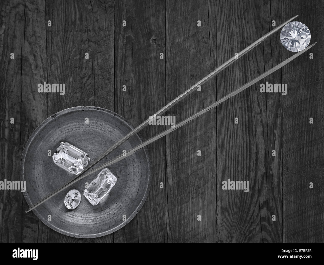 monochromatisches Bild der verschiedenen Diamanten in einer Arbeitsgruppe Messing Tablett und Pinzette Stockfoto