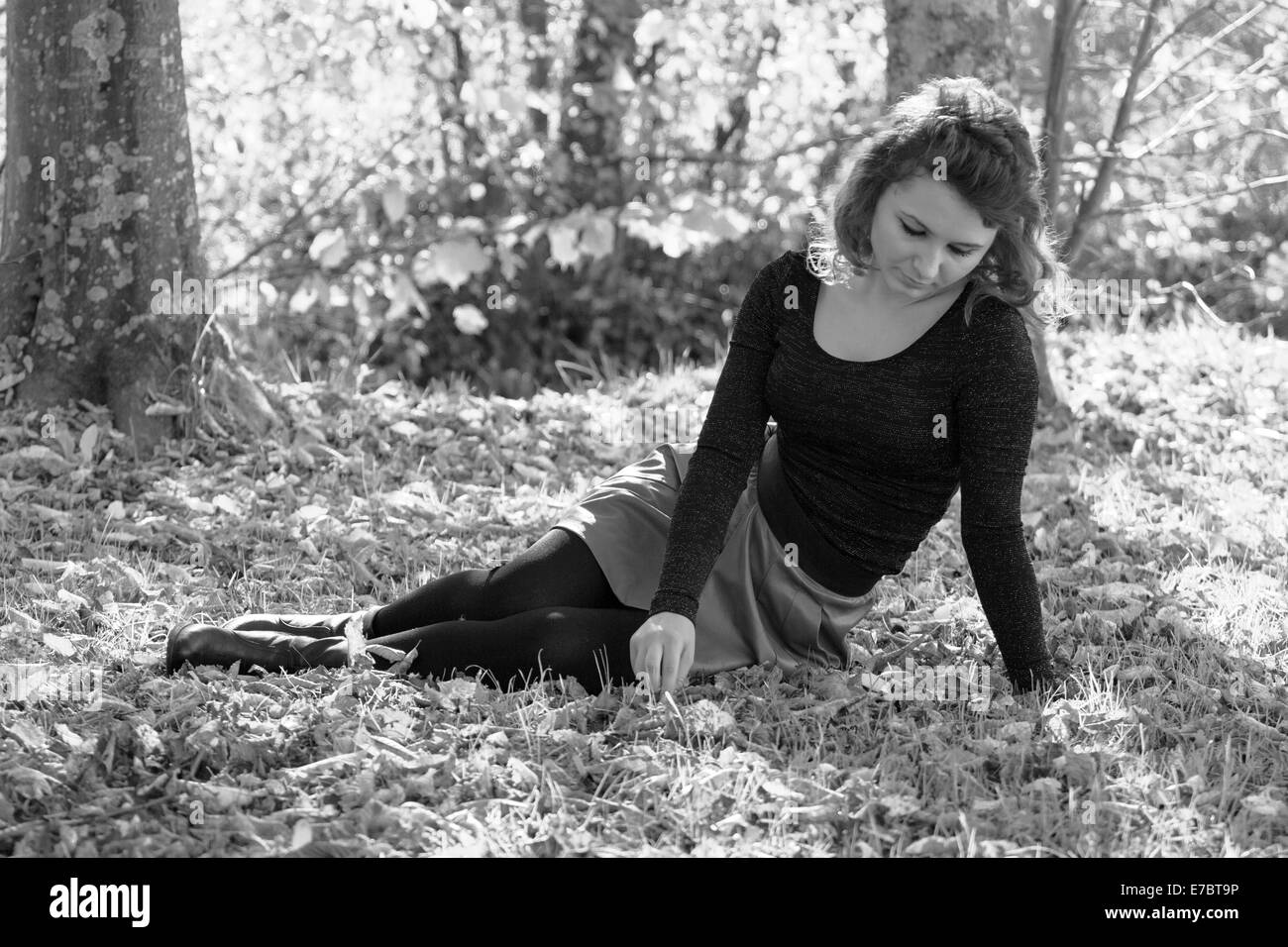 Traurige Frau saß allein im Wald. Stockfoto