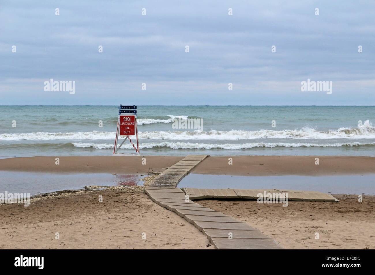 Leere Rettungsschwimmer Turm mit No Lifeguard am Pflicht Schild am einsamen Strand am Ende der Saison schwimmen. Stockfoto