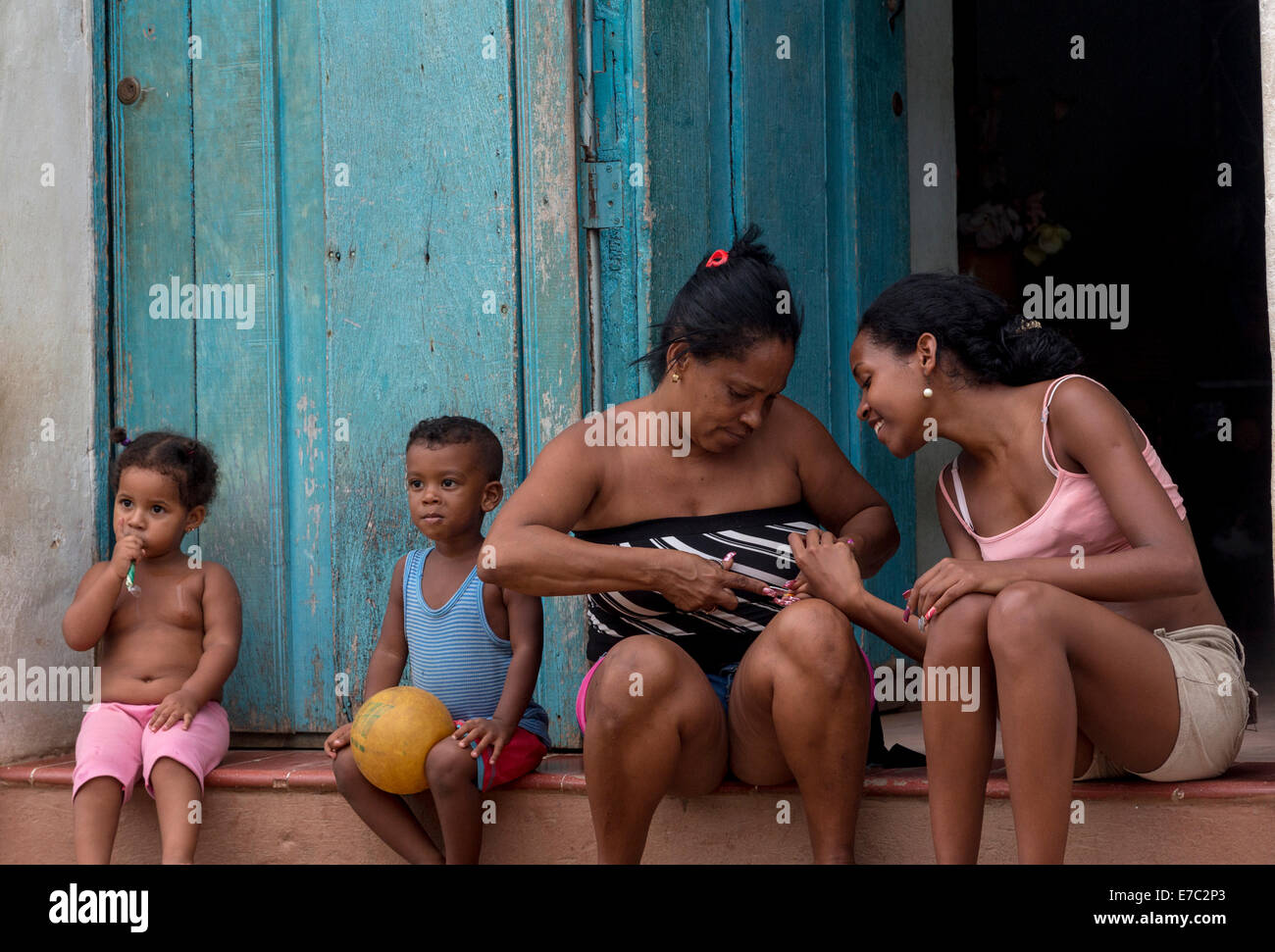 ältere Frau Maniküre eine jüngere vor Haustür, Trinidad, Kuba Stockfoto