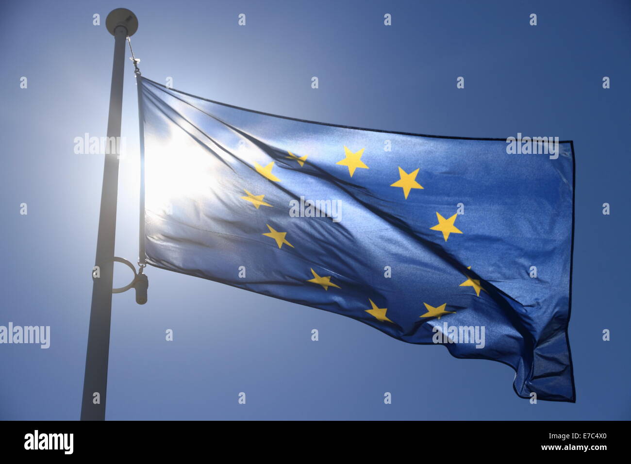 Europäische Flagge mit zwölf gelben Sternen auf blauem Himmel, Contre-Jour Stockfoto