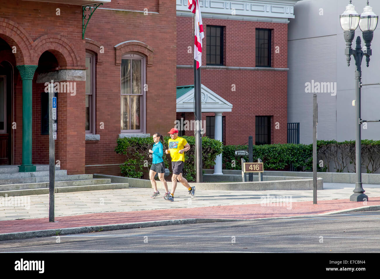 Passen Sie junges Paar Joggen vorbei an der alten historischen Nassau County Courthouse in Fernandina Beach, Florida, USA. Stockfoto