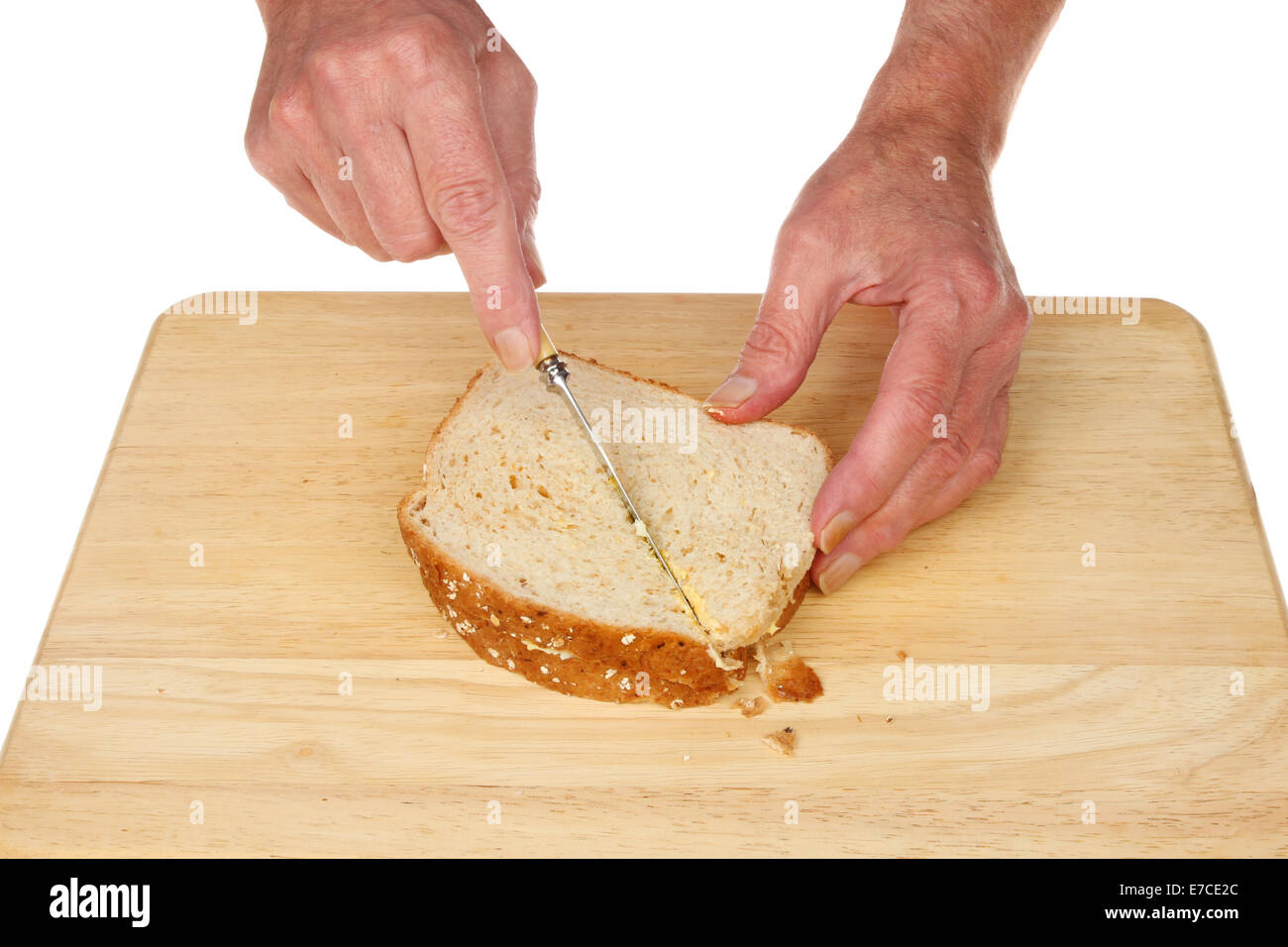 Paar Hände schneiden einen Sandwich auf einem Brett aus Holz Essen Vorbereitung Stockfoto