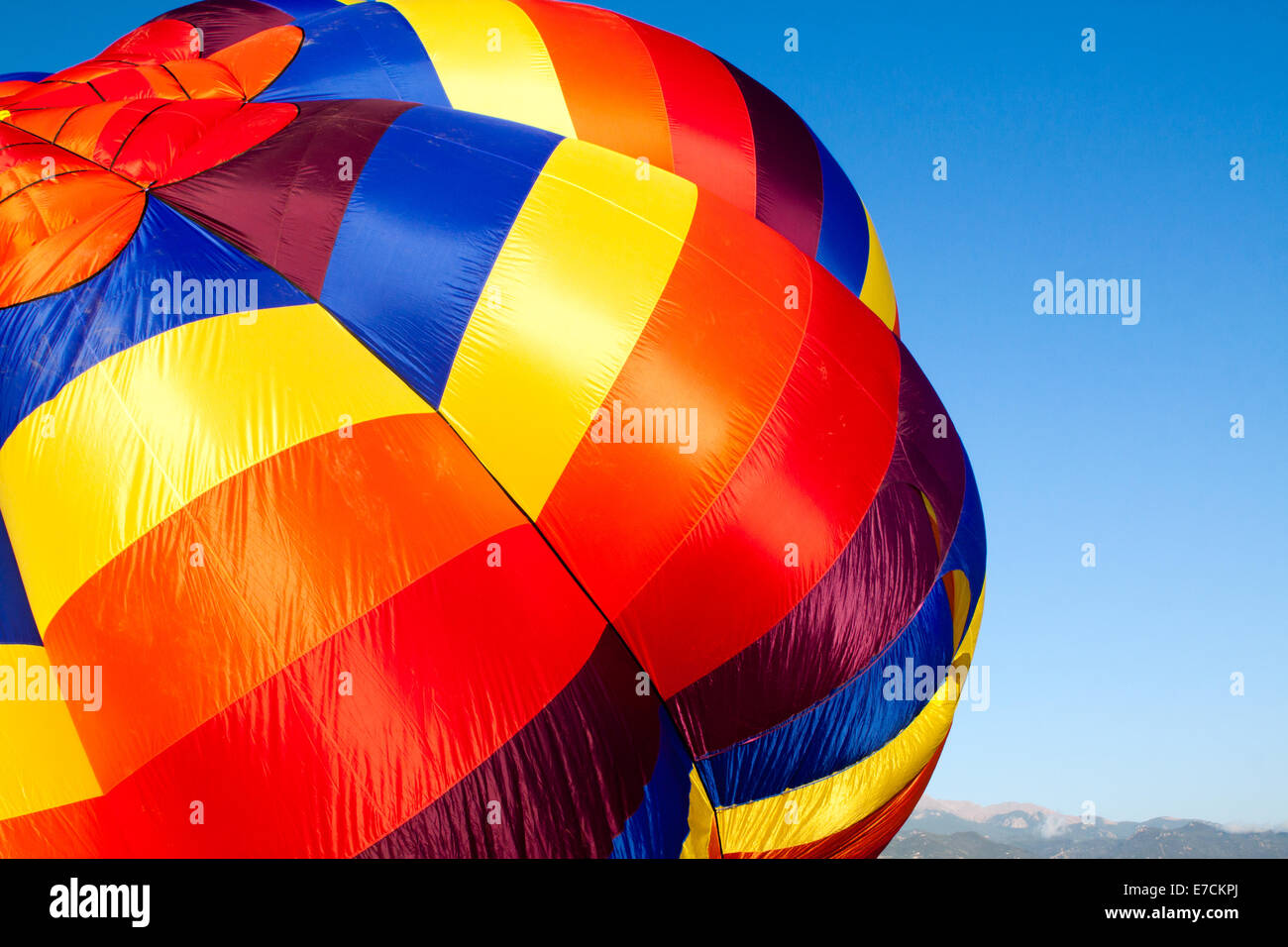 Einen bunten Luftballon wird aufgeblasen mit den Rocky Mountains in der Ferne Stockfoto