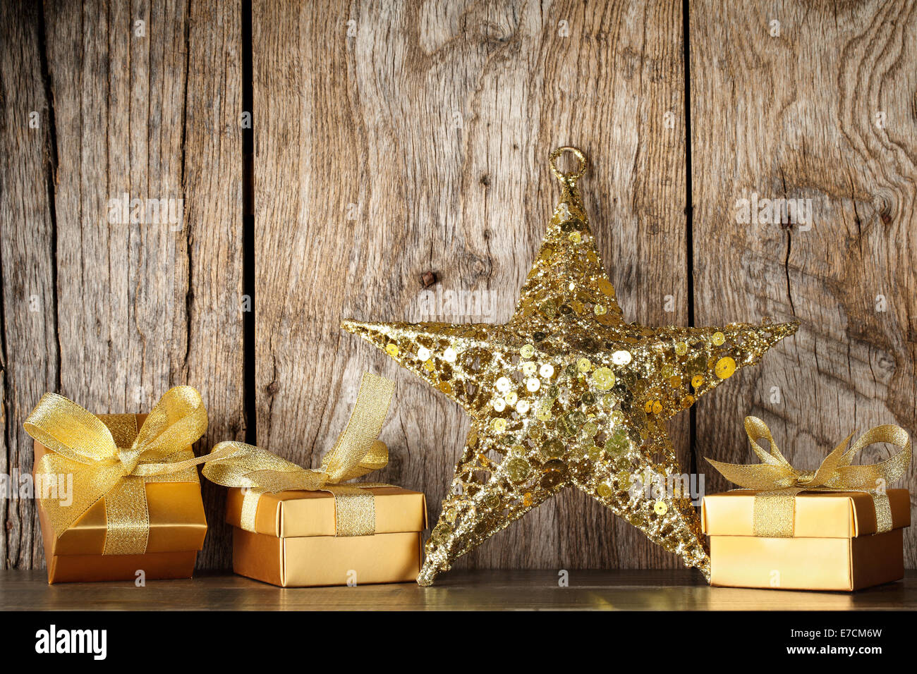 Geschenkboxen und goldene Sterne auf Grunge Holz Hintergrund Stockfoto