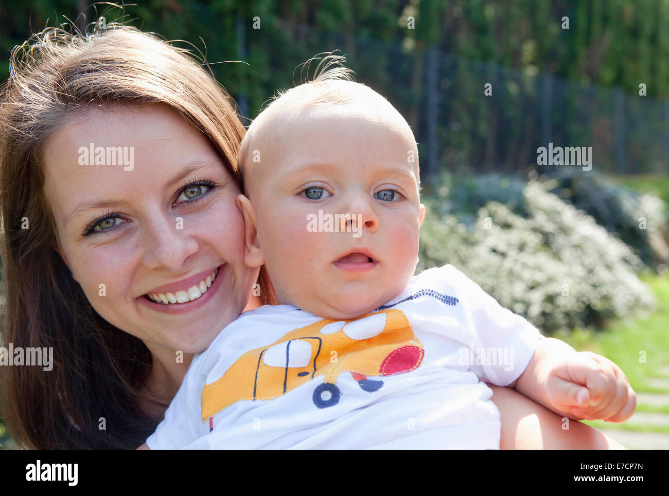 Junge Mutter mit ihrem Baby in den Garten lächelnd Stockfoto