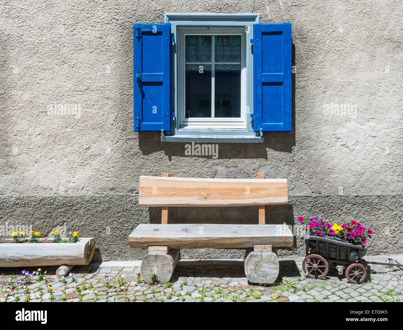 Fenster mit Fensterläden, Holzbank. Kleinlaster, stilisiert als Blumentopf. Gemütliche, einfache alte Zeiten leben. Stockfoto