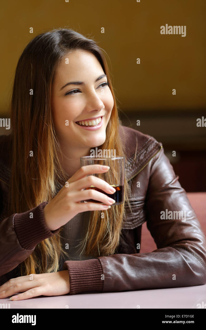 Glückliche Frau denken und halten eine Erfrischung in einem restaurant Stockfoto