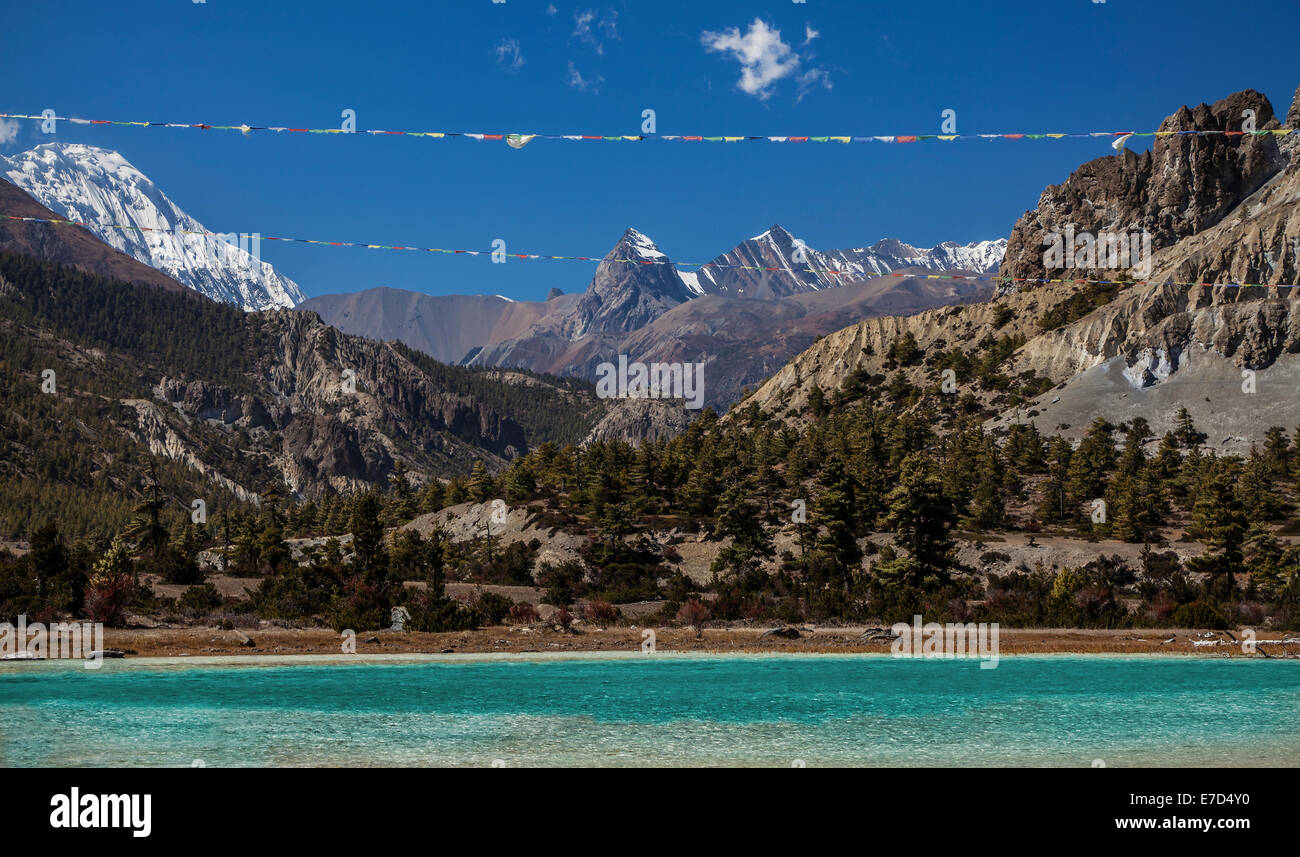 Gebetsfahnen über Bergsee im Annapurna Circuit Trail, Nepal. Stockfoto