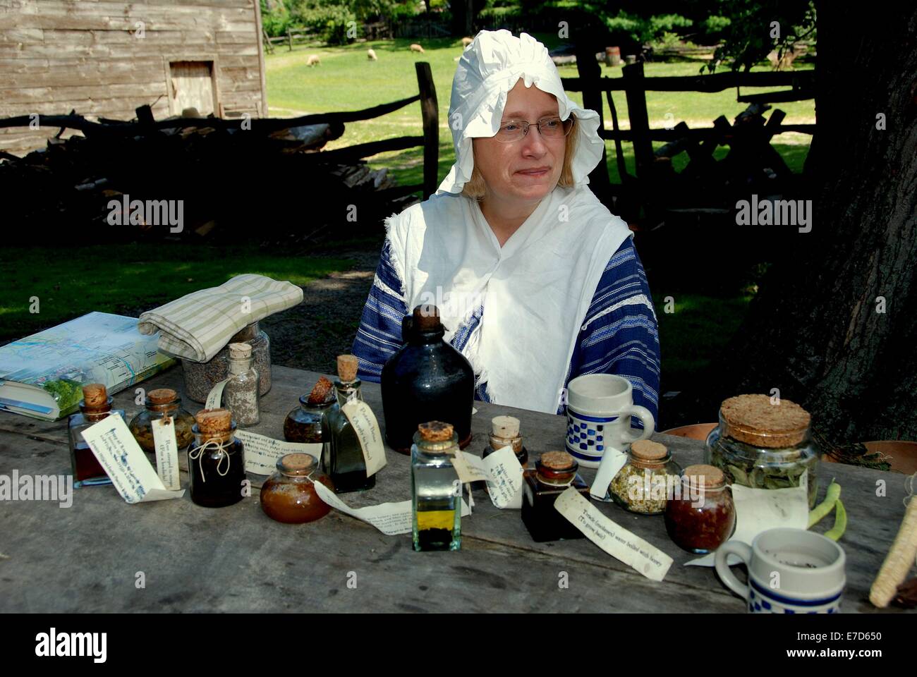 SLEEPY HOLLOW, NY: Frau Dolmetscher tragen Tracht aus dem 18. Jahrhundert mit traditionellen kolonialen Arzneimittel und pflanzliche Tränke Stockfoto