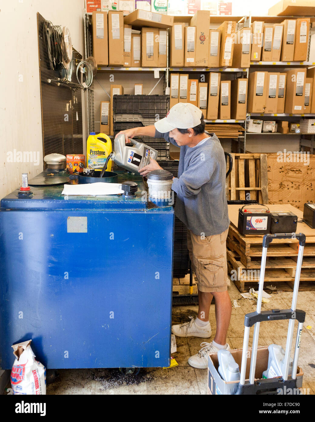 Man recycelt gebrauchter Motorenöl im Autoteile-Lager (Öl recyceln) - USA Stockfoto