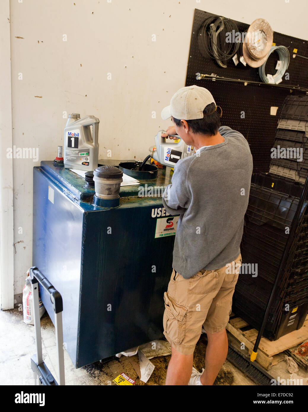 Man recycelt gebrauchter Motorenöl im Autoteile-Lager (Öl recyceln) - USA Stockfoto