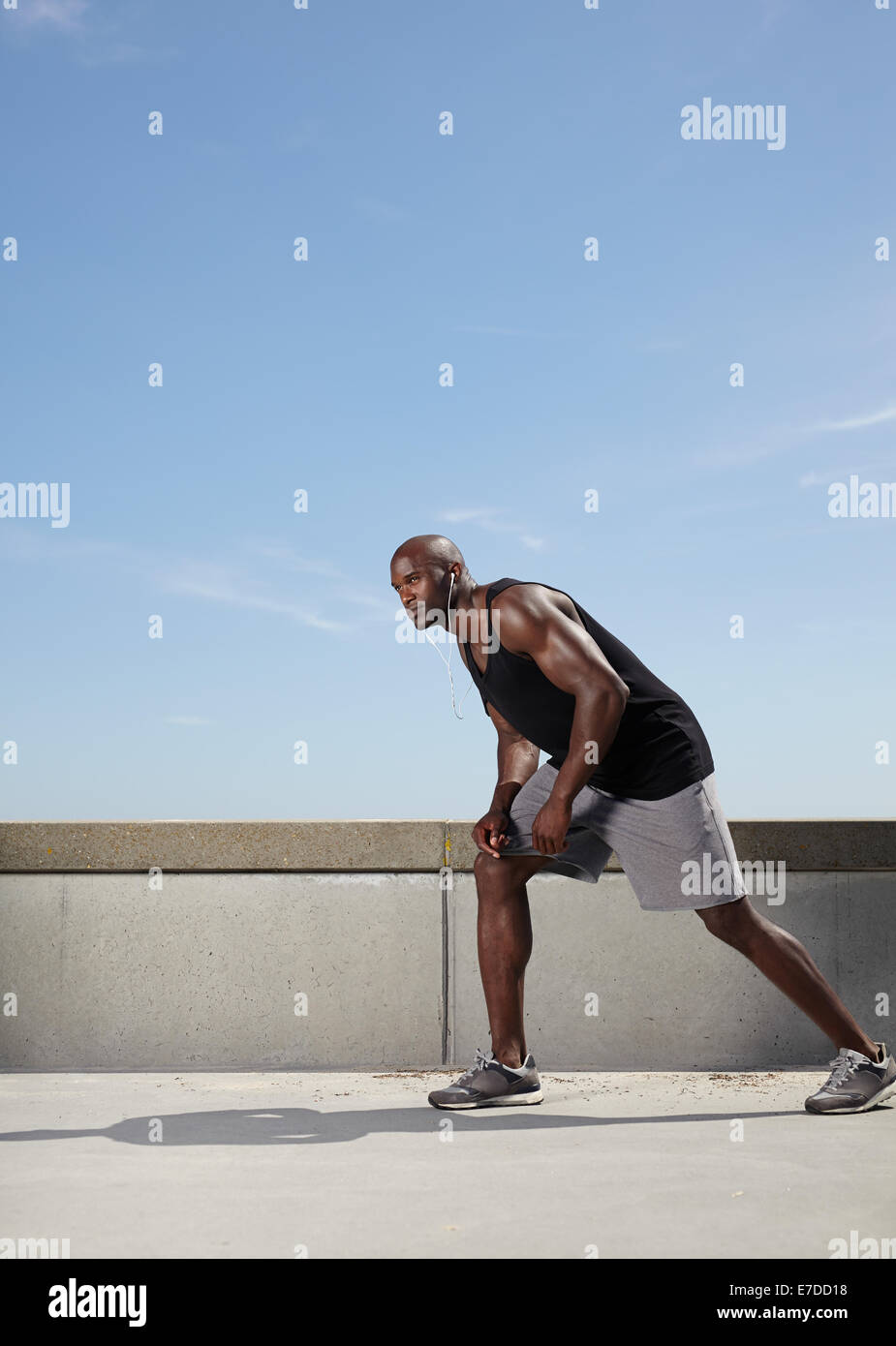 Voller Länge Bild von Passform und starke junge männliche Modell bereit für seinen Lauf. Muskulöse Sportler im Freien. Stockfoto