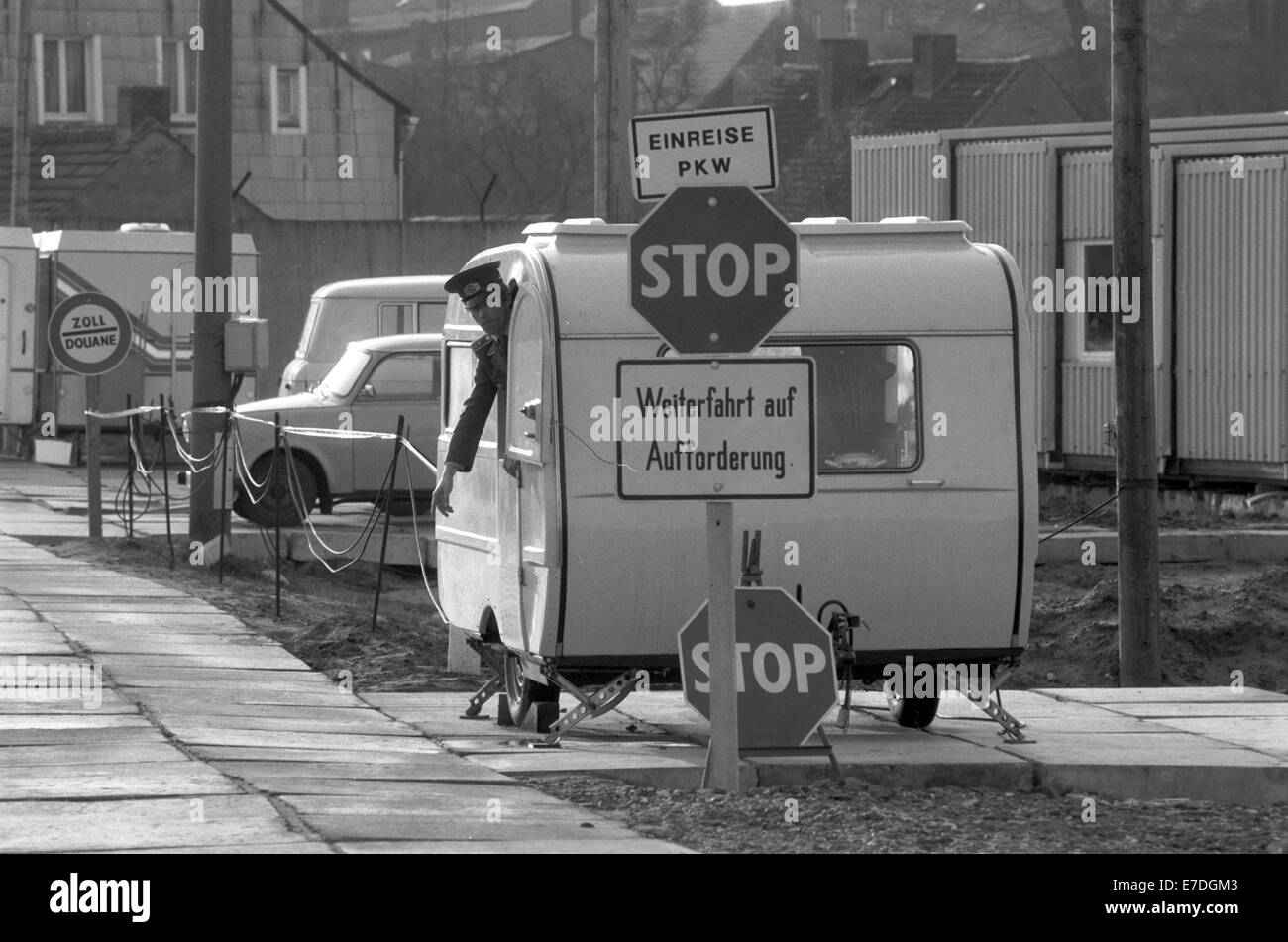 Ein DDR-Soldat hält seinen Arm aus einem camping Wagen die obligatorische Formalitäten am vorläufigen Grenzübergang in Scheibenventile, Deutschland, Februar 1990 eingerichtet worden. Nach dem Fall der Mauer im November 1989, dem Rücken und her Reisen der DDR-Bürger in ihre Pässe gestempelt wurde. Foto: Eberhard Kloeppel Stockfoto