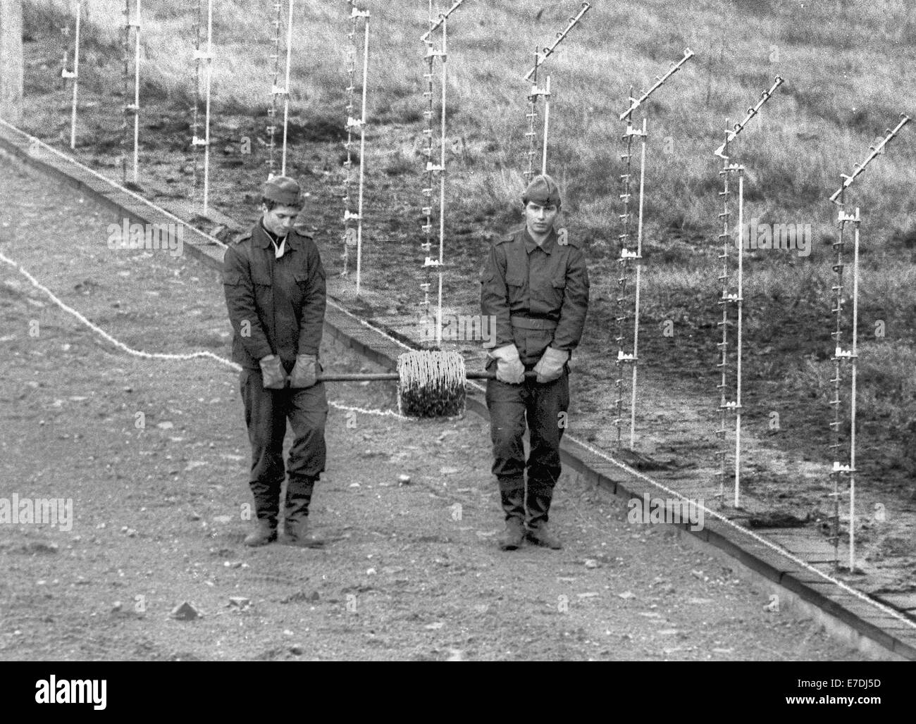 DDR-Grenzsoldaten rekonstruieren die Wandmontage, Stacheldraht und Spikes unter den Fenstern, um Flüchtlinge gore. Der Tod-Streifen in der Mitte und der Wand auf der rechten Seite. Stockfoto