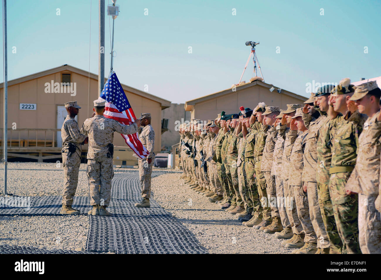 Koalitionstruppen in regionalen Befehl Südwesten Gruß als Flagge der Vereinigten Staaten während der 9/11 Gedenkfeier 11. September 2014 in Camp Leatherneck, Provinz Helmand, Afghanistan ausgelöst wird. Stockfoto