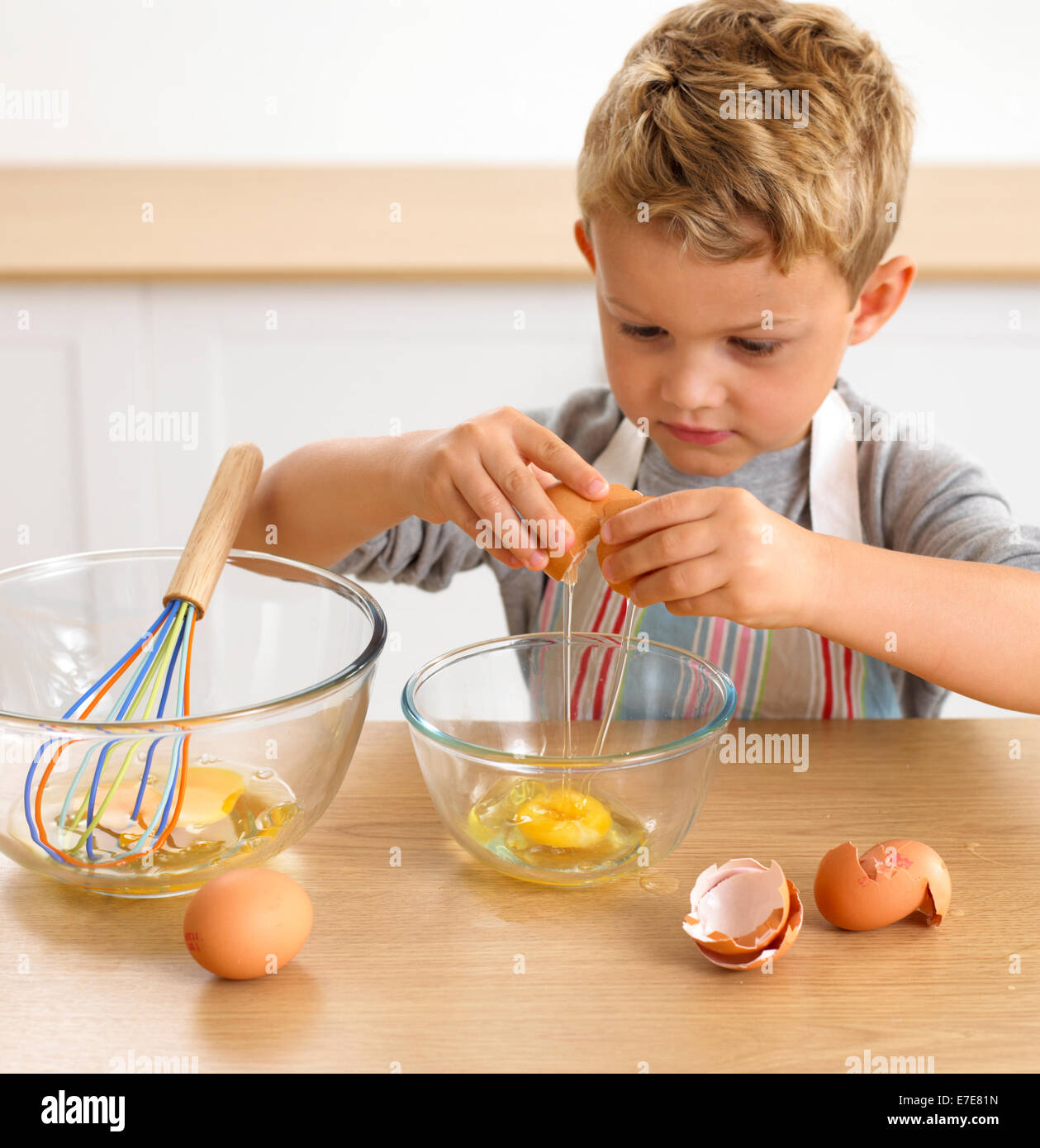 Junge knacken Ei in Schüssel, 4 Jahre Stockfoto